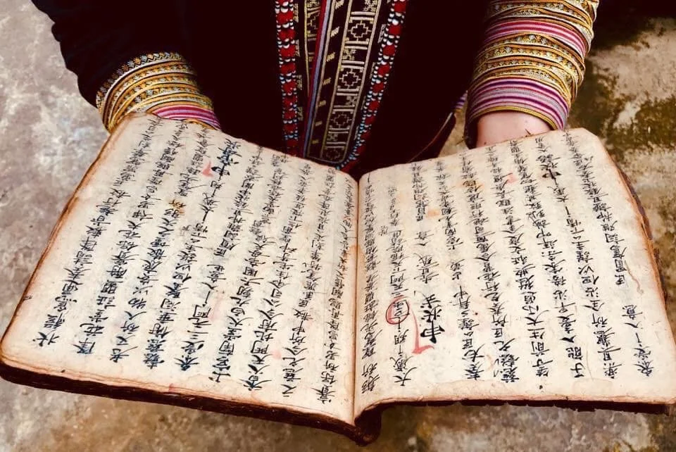 Open Red Dao ritual manuscript written on handmade paper with traditional Chinese-derived Dao characters in Sapa, Vietnam.