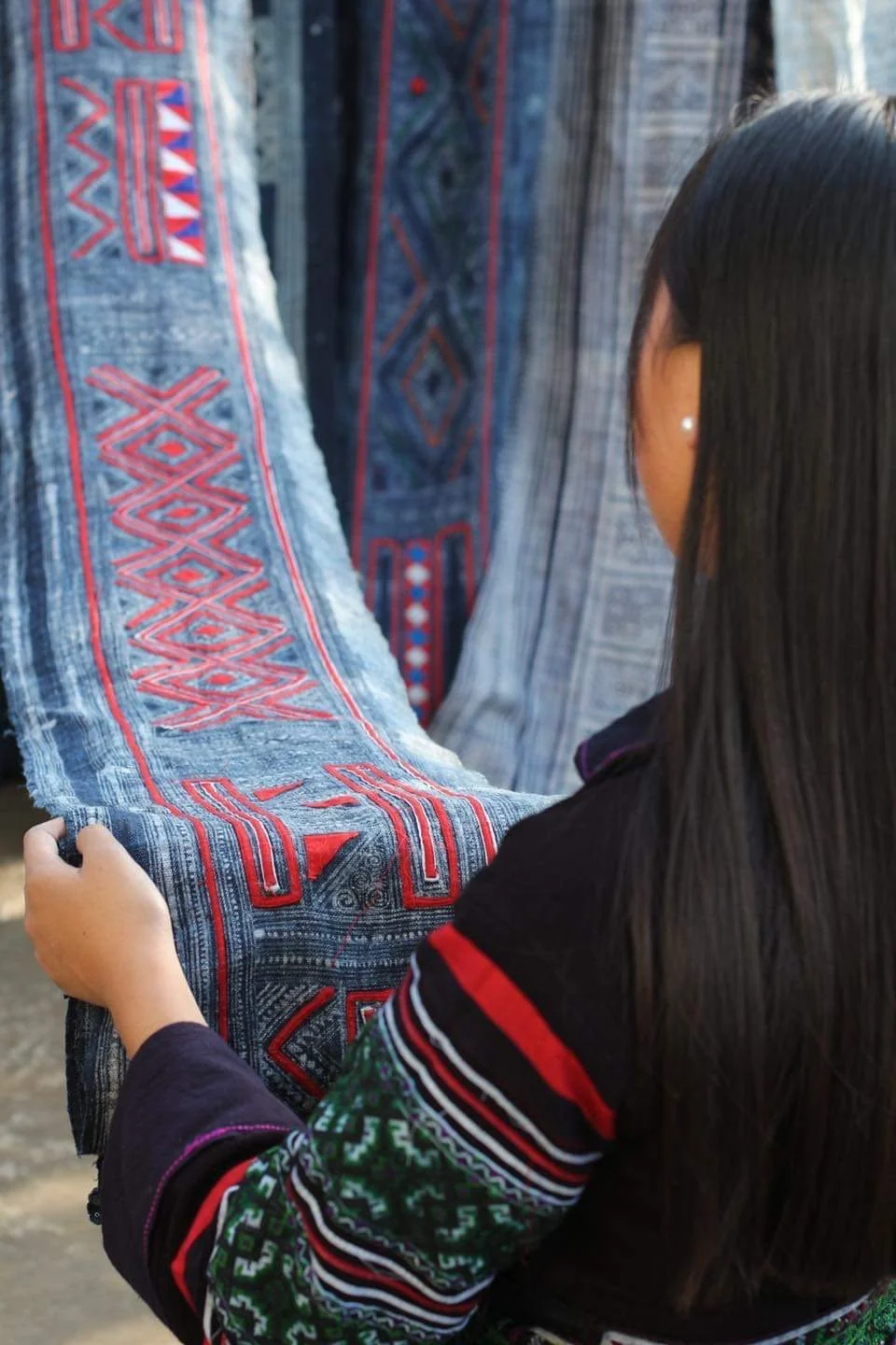 A Hmong Woman appreciate the hard work in batik Hemp roll that they put in the clothes