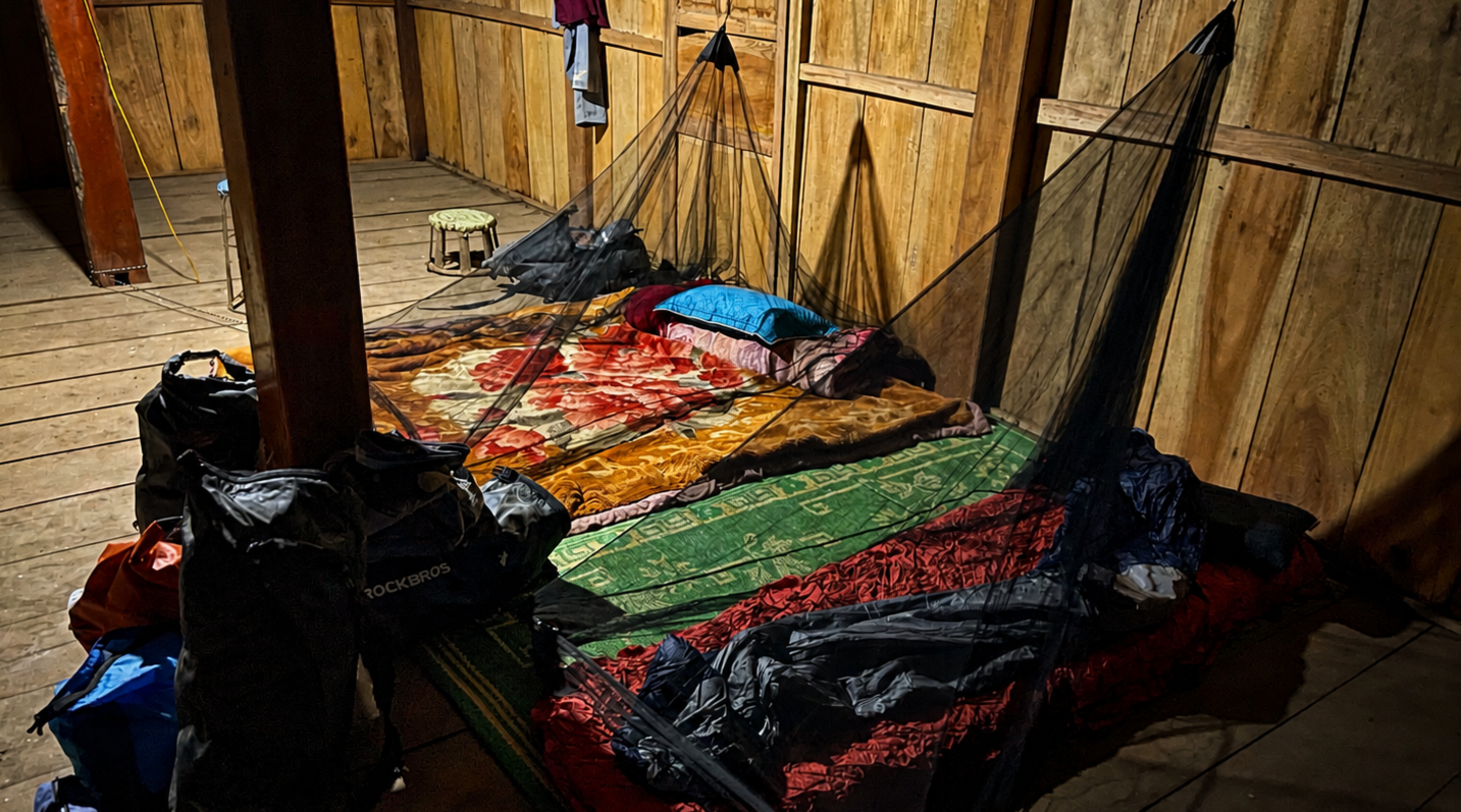 Simple homestay sleeping area in Dien Bien Province with mattresses and mosquito nets inside a traditional wooden house