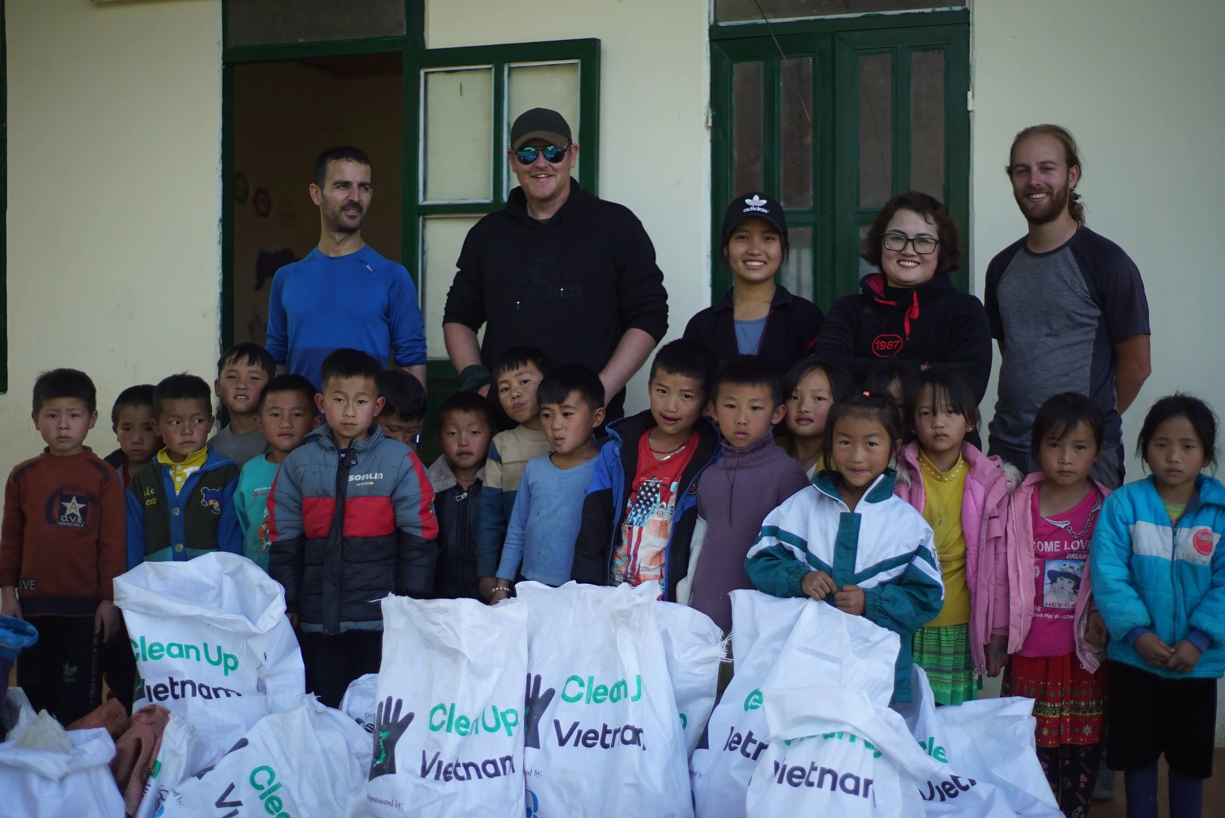 Local Hmong children and volunteers from Clean Up Vietnam posing together after a successful clean-up day in Sapa.