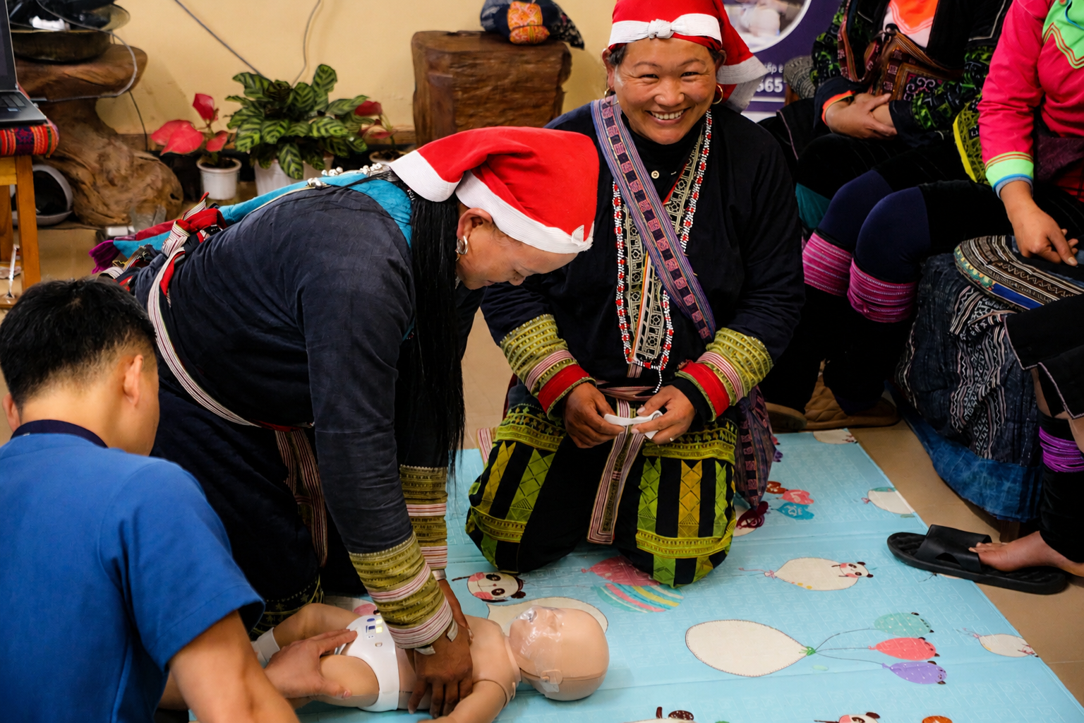 Dao guides practicing CPR techniques during a hands-on first aid training.
