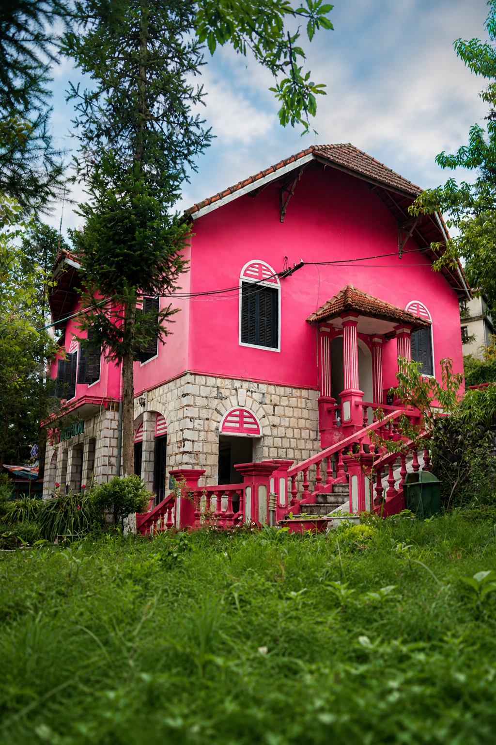 Photograph of a restored French colonial villa in Sapa with brightly painted walls and stone foundations, taken in 2026.