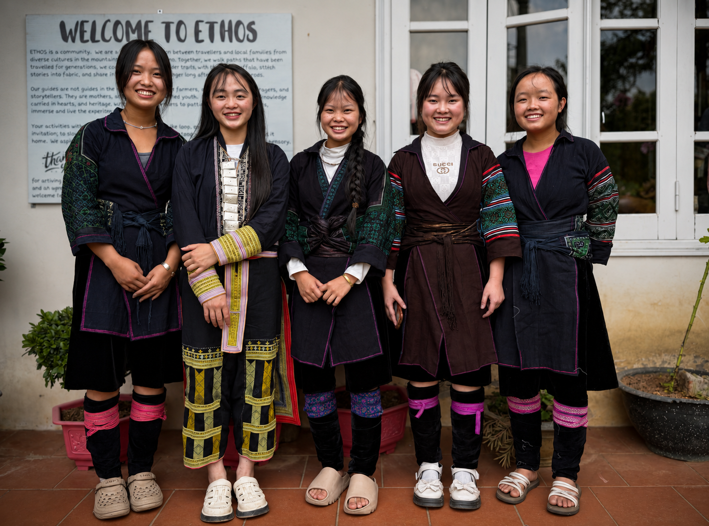 Five young women wearing Hmong and Red Dao clothing stand together outside the ETHOS office in Sa Pa.