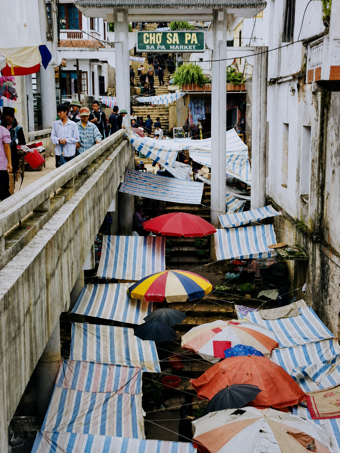 Entrance to Sapa Market, with colourful tarpaulins covering busy market stalls and shoppers arriving from surrounding mountain villages.