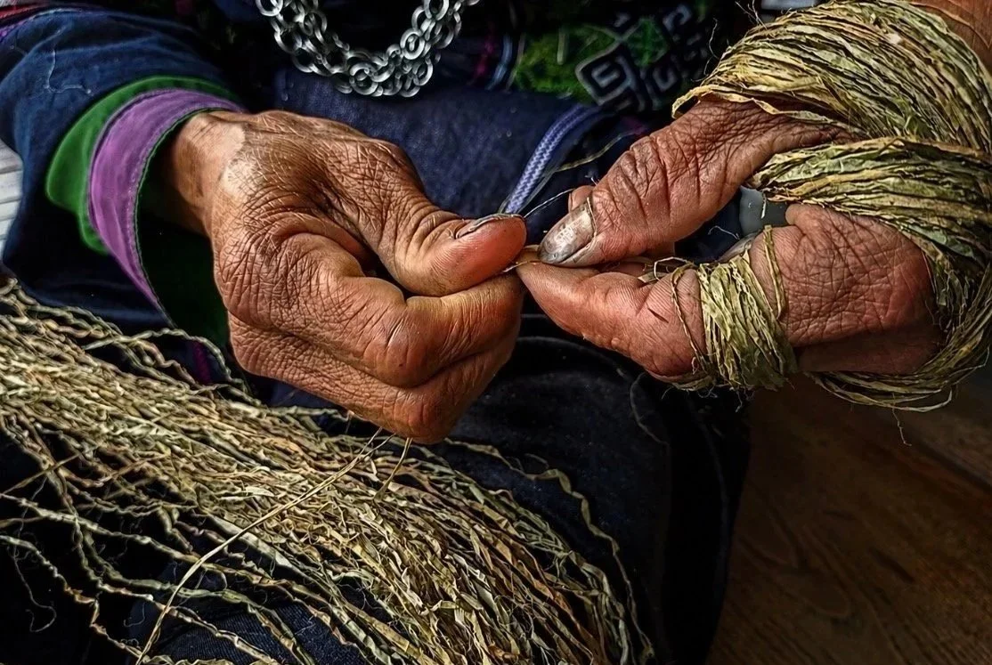 Close-up of Hmong hands twisting and preparing hemp fibres for weaving