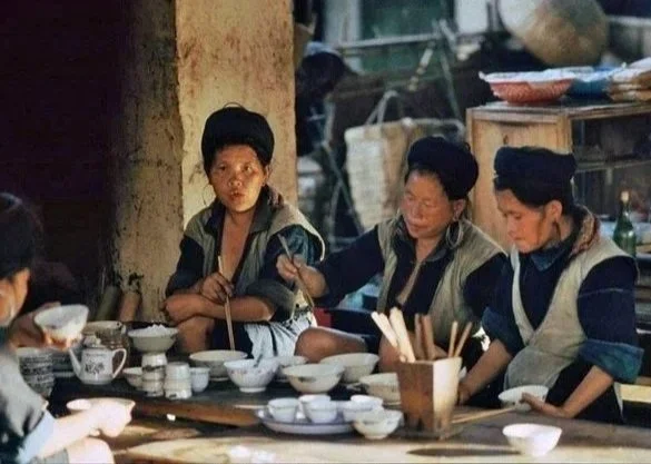 Photograph of Hmong women sharing food and conversation inside Sapa Market in 1992 during the reopening of tourism in the highlands.