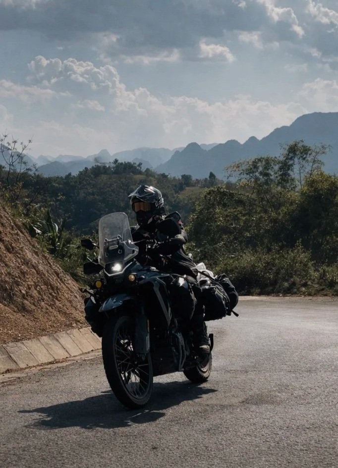 Motorbike rider travelling along a winding mountain road in northern Vietnam.