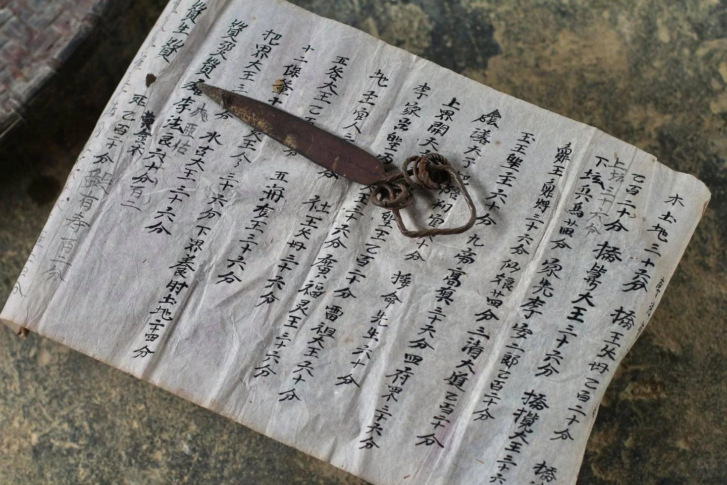 Traditional Red Dao ritual knife resting on a handwritten ceremonial document, one of the sacred implements used by ritual masters during religious ceremonies in northern Vietnam.