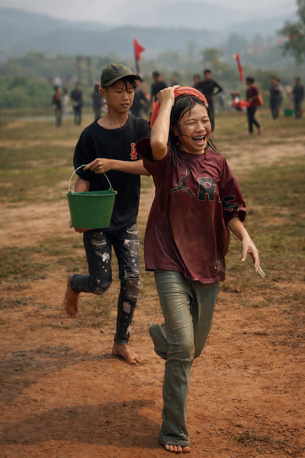 Lao teenagers running barefoot along a dusty village path, carrying buckets of water and laughing as the water-splashing celebrations intensify during Bun Vốc Nặm.