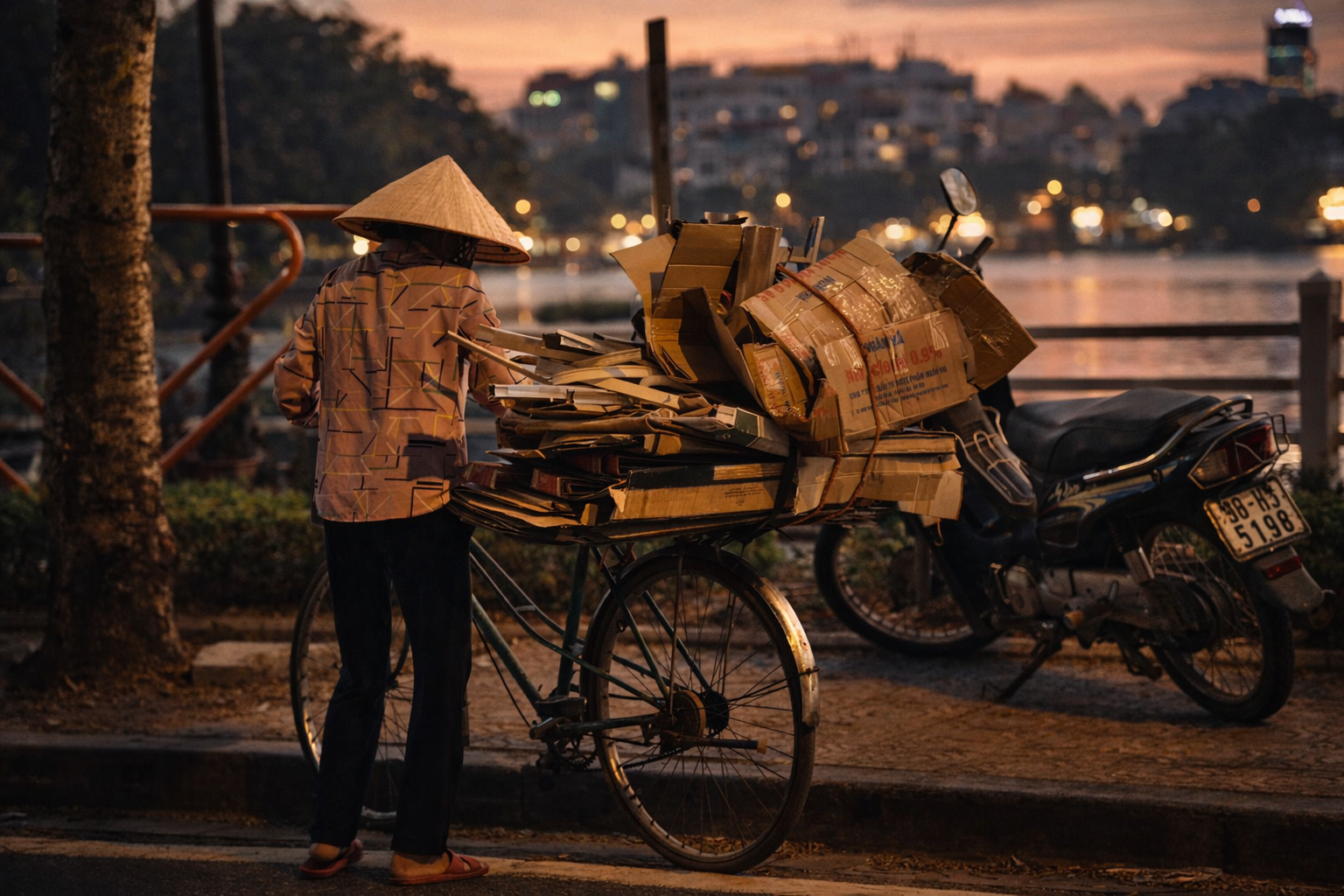 A local lady in Ha Noi carrying card board around the bight light in the city