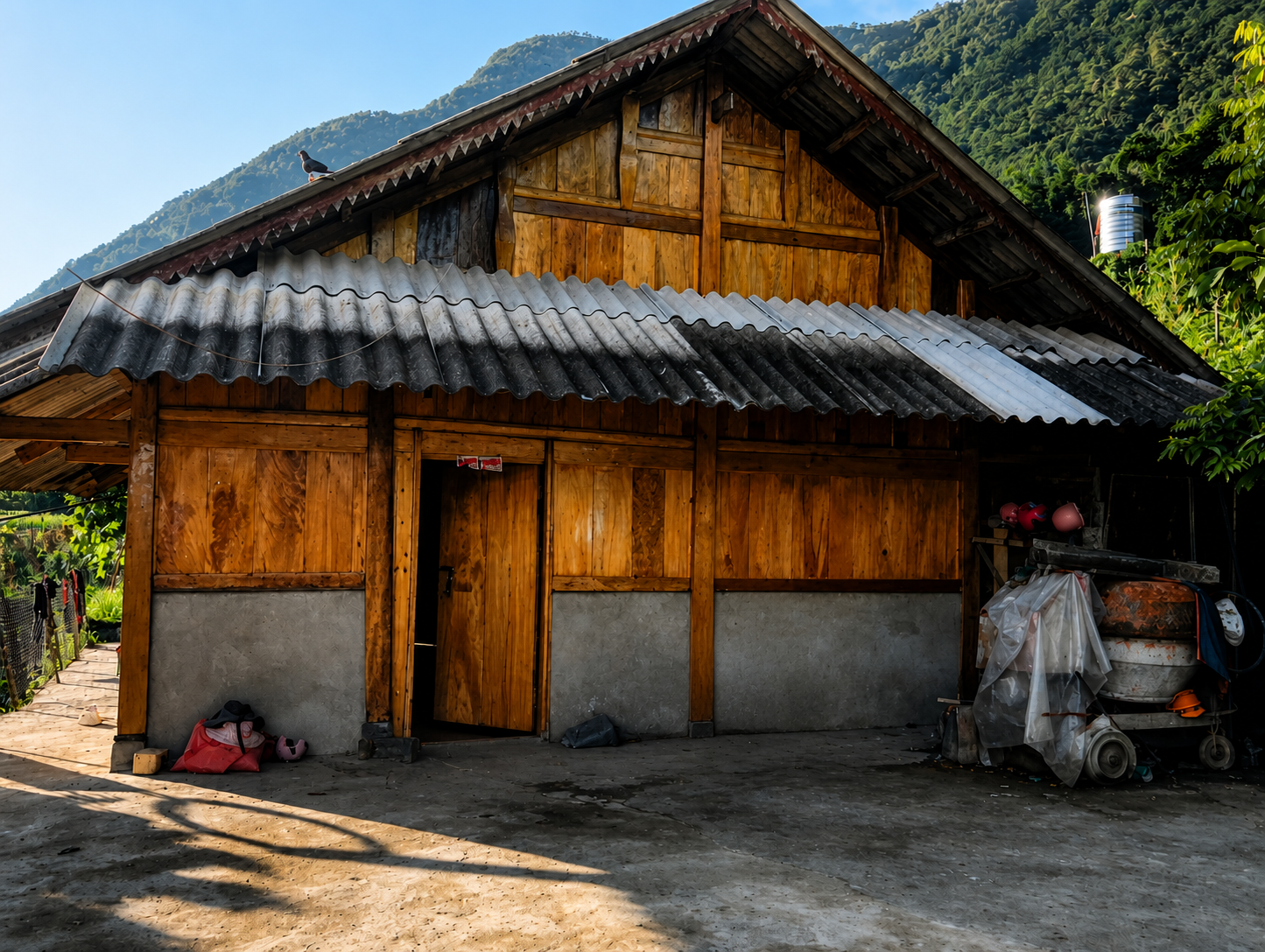 The wooden family home of Sùng Thị Sinh in Sử Pán, Sa Pa, surrounded by forested mountains.
