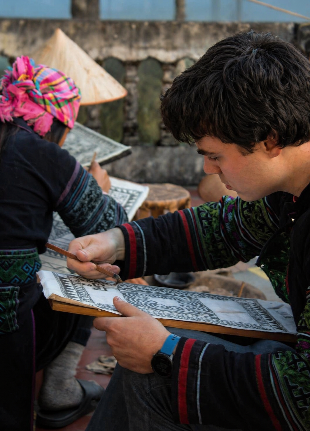 Traveller practising traditional batik wax drawing during a workshop in Sapa