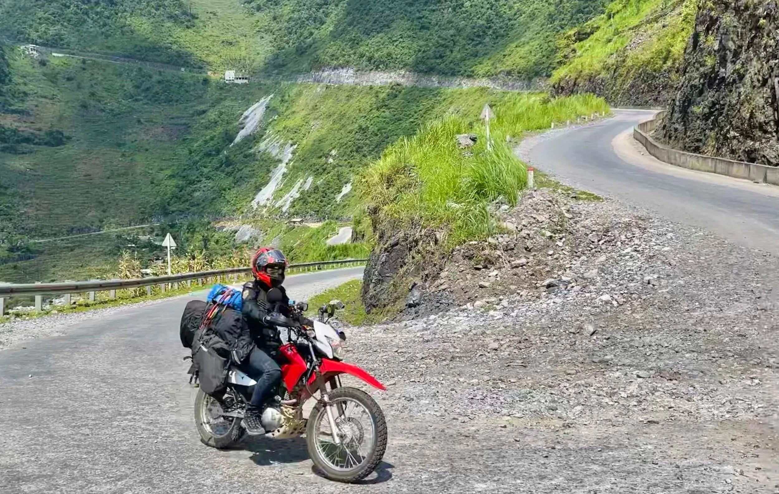 Motorbike rider approaching a steep bend on a mountain road in northern Vietnam.