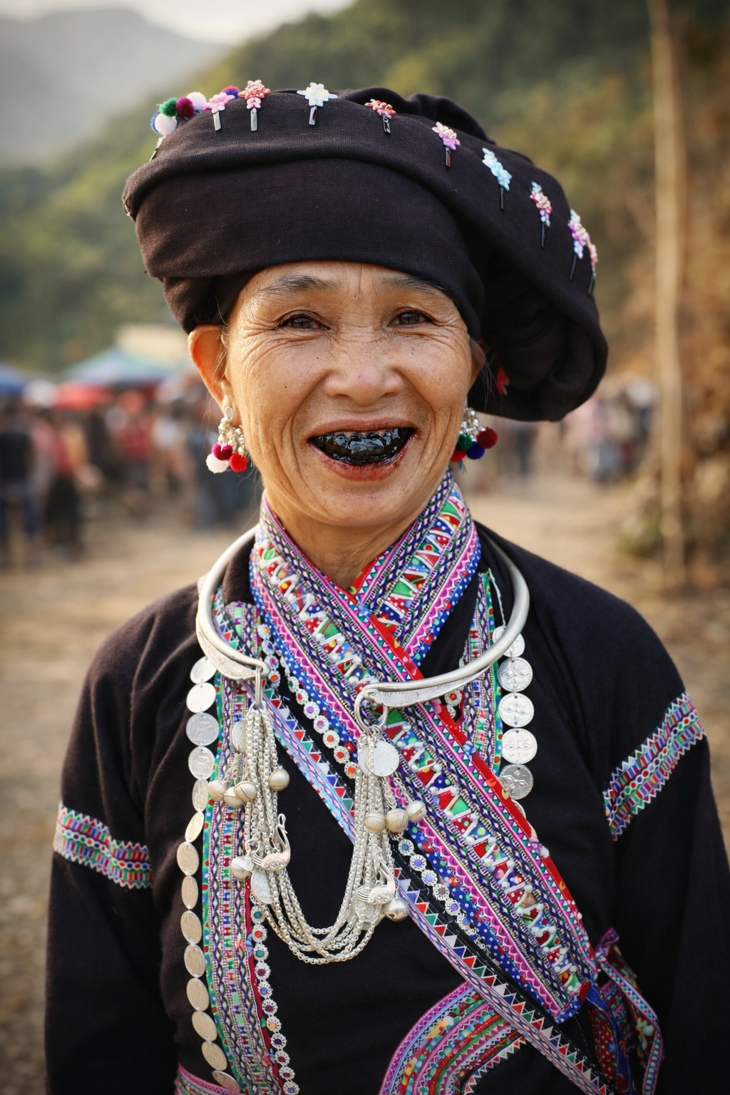 An elderly Lao woman smiling warmly, her blackened teeth and traditional embroidered clothing reflecting cultural identity and beauty during a festival gathering in Lai Châu.