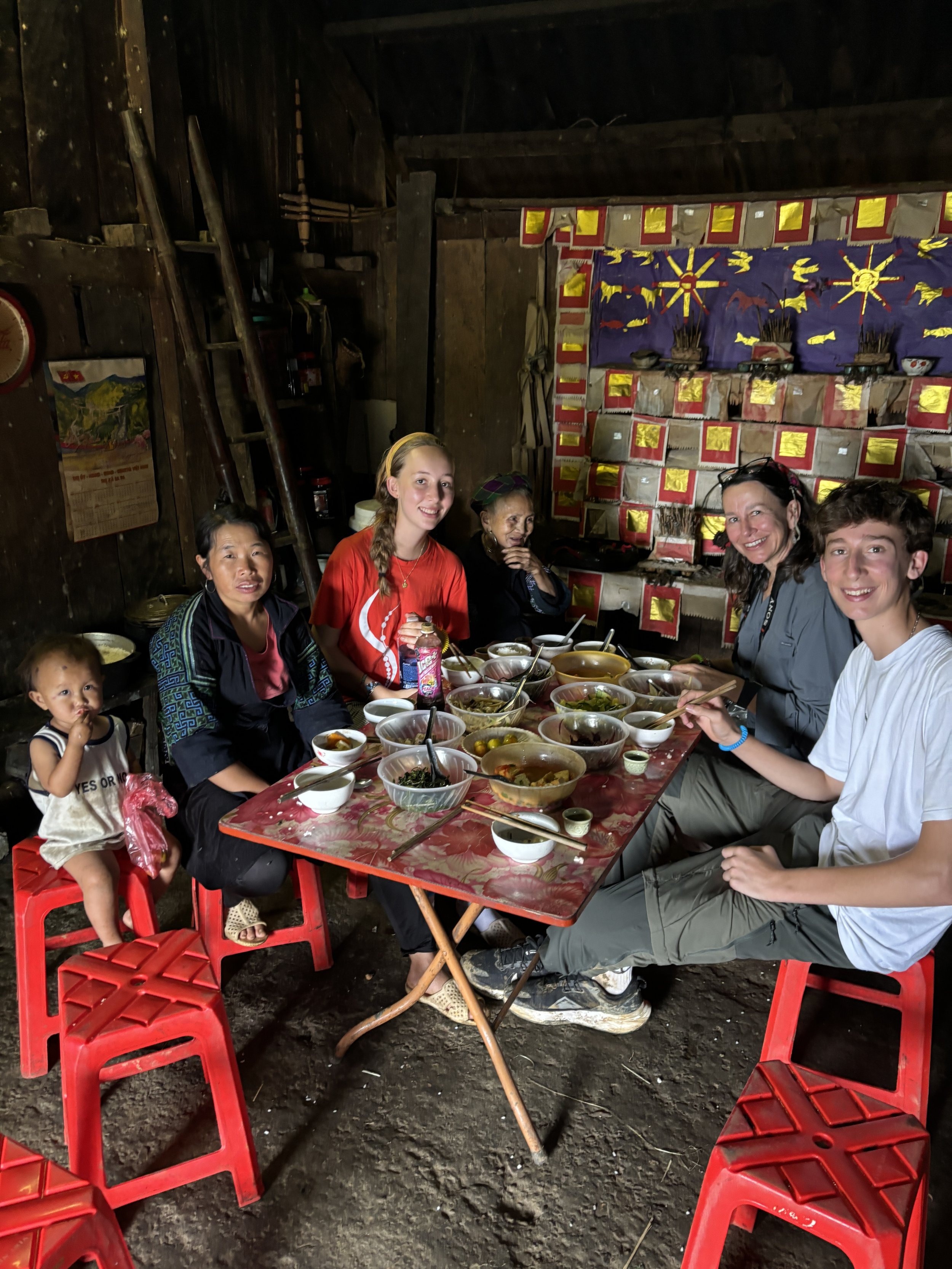 Families sharing traditional meal in local home in Sapa