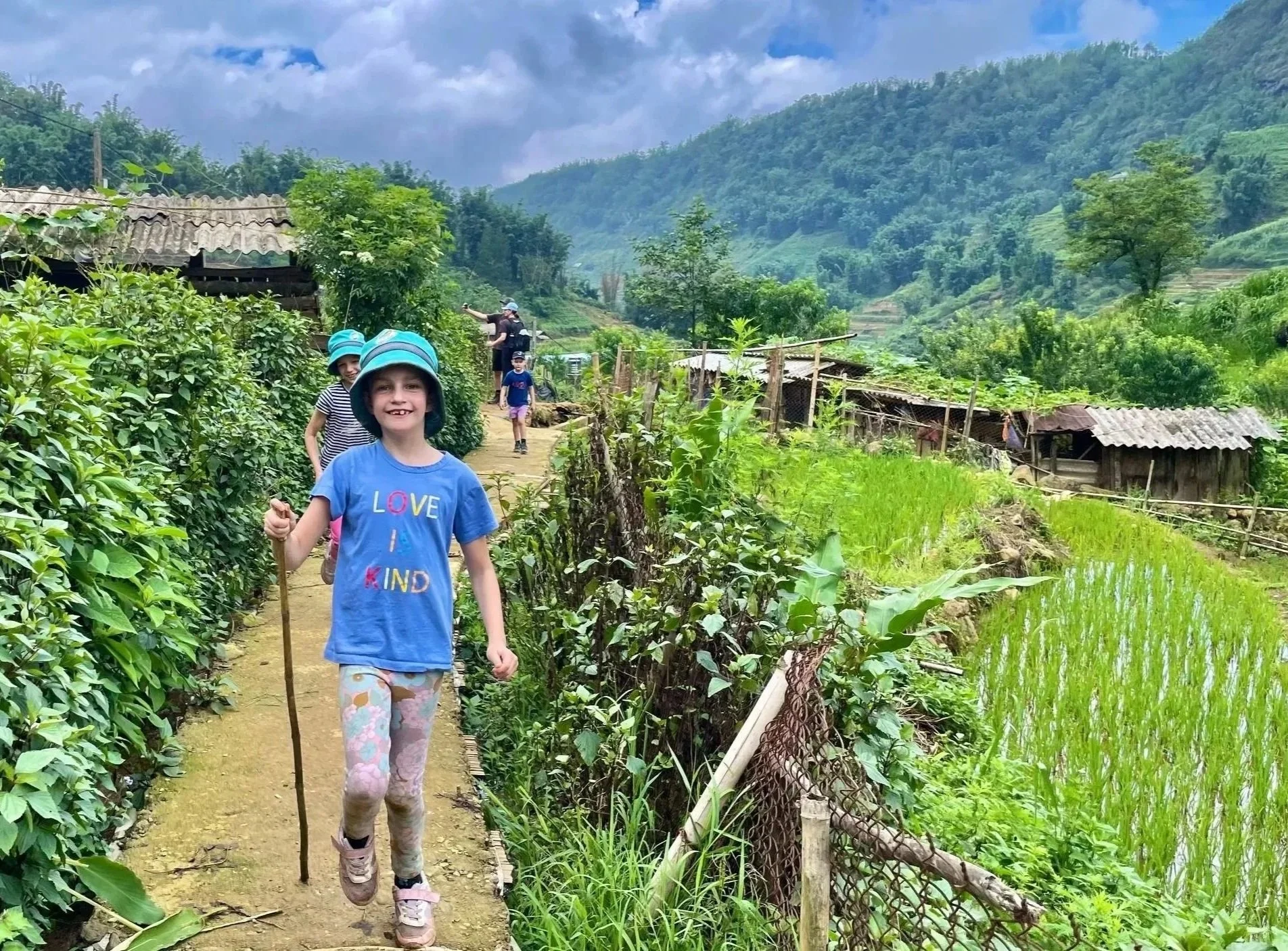 Child walking along path beside rice terraces in Sapa