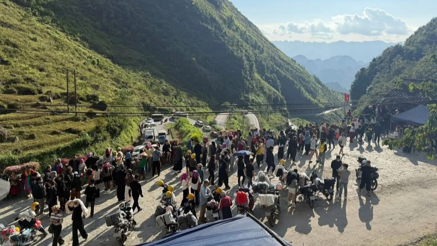 Large groups of motorbike riders gathered on a road in Ha Giang showing the scale of tourism and crowding on the loop