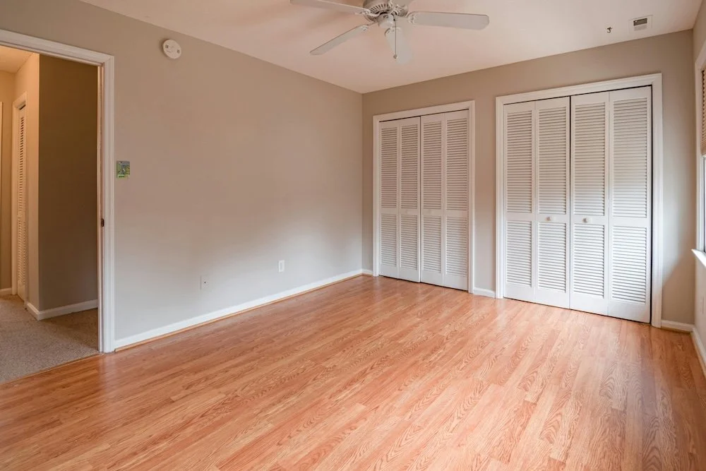 Professional real estate photography of a spacious empty bedroom with hardwood floors in Ottawa by Charmcam.