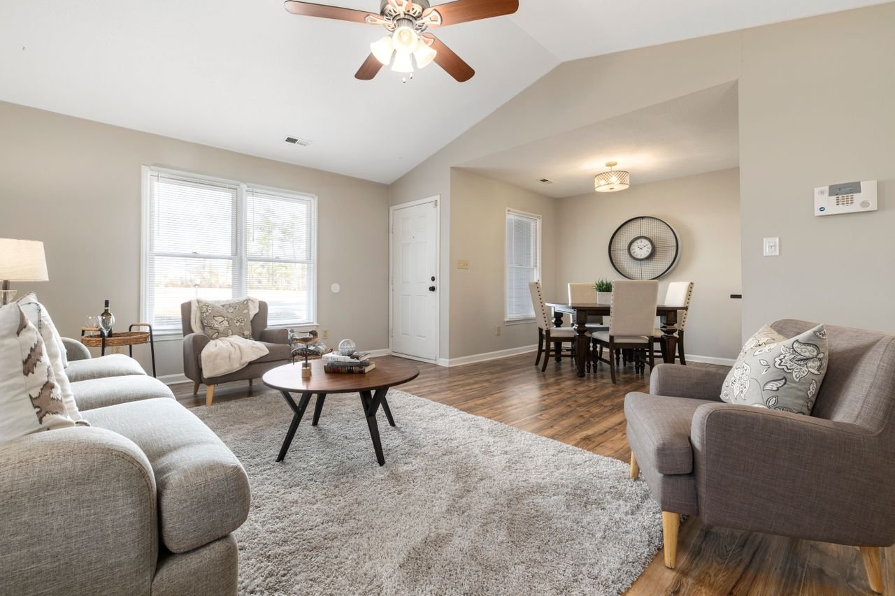 Professional real estate photography of a beautifully furnished open concept living and dining room with a vaulted ceiling in Ottawa by Charmcam.