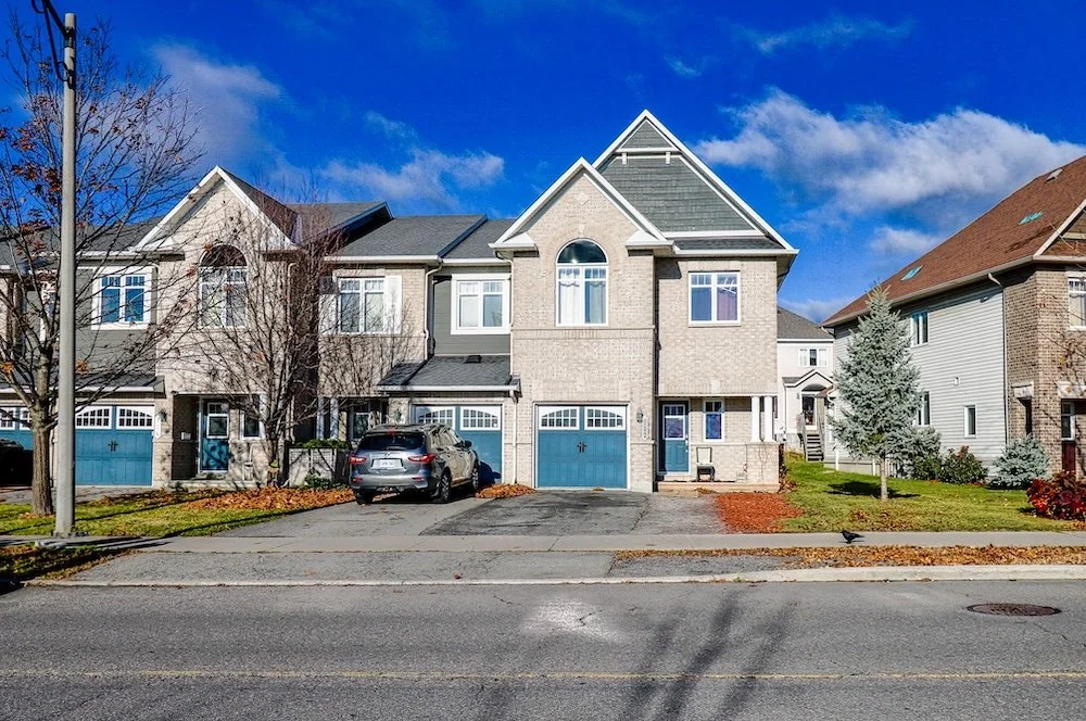 Professional real estate photography of a modern townhouse exterior under a blue sky in Ottawa by Charmcam.