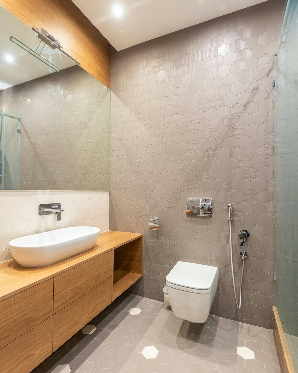 Professional real estate photography of a luxury modern bathroom with a floating wooden vanity and stylish vessel sink in Ottawa by Charmcam.