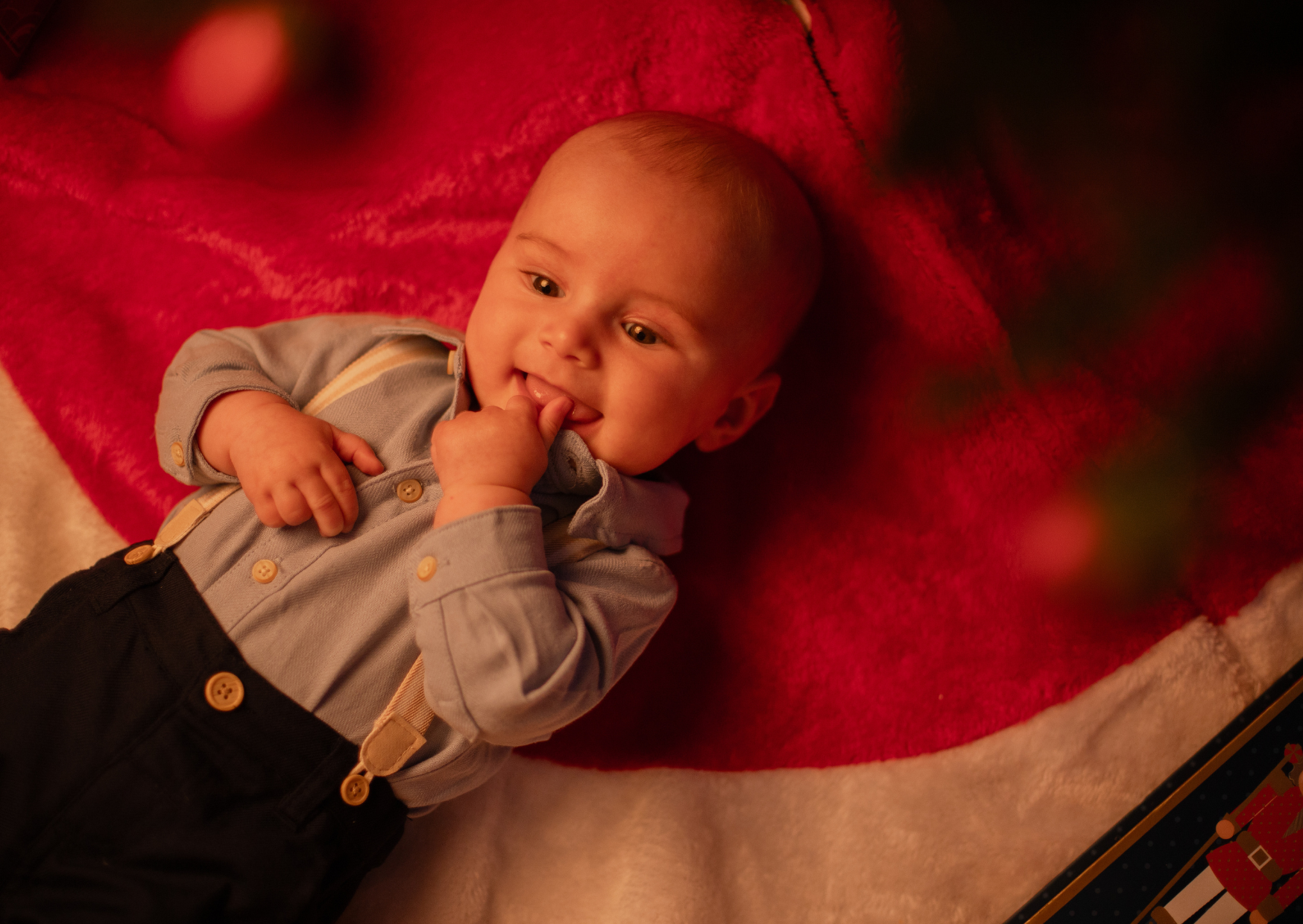 baby boy under the christmas tree smiling