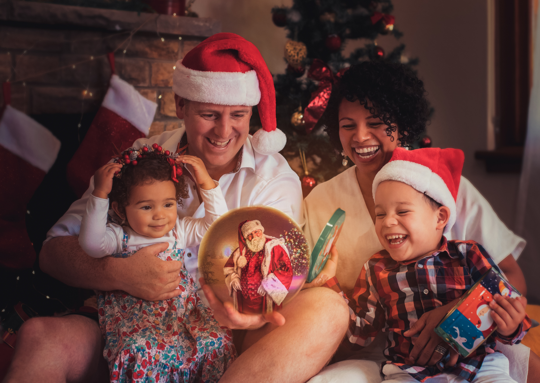 Family celebrating Christmas by opening gifts with a decorated Christmas tree in the background, all wearing Santa hats and sharing joyful moments.