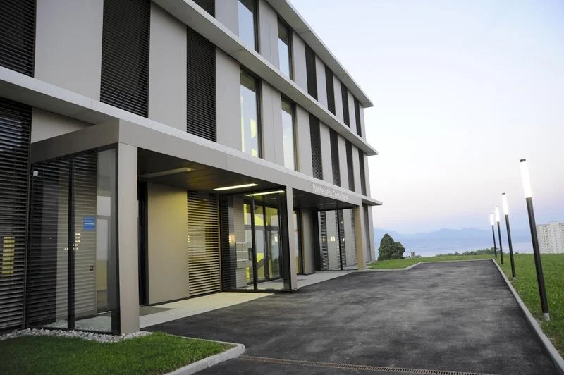 Bâtiment moderne avec entrée et lampadaires extérieurs