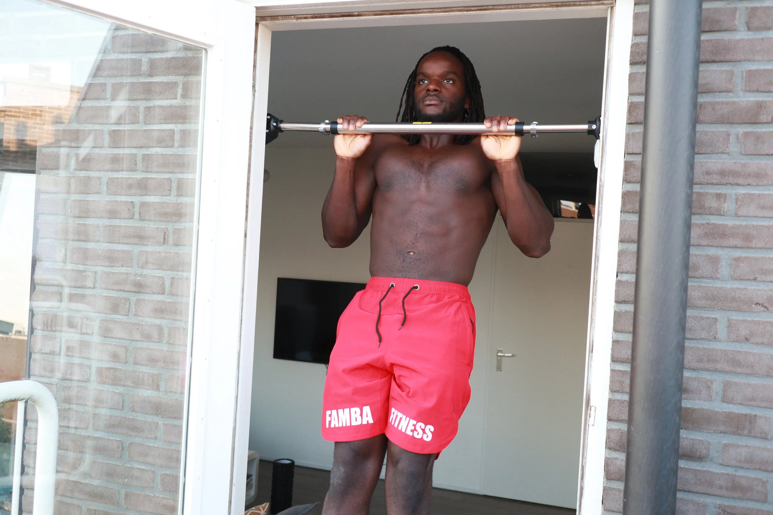 a man doing pull ups on a home pull up bar. this is a doorway pull up bar that secure and reliable.