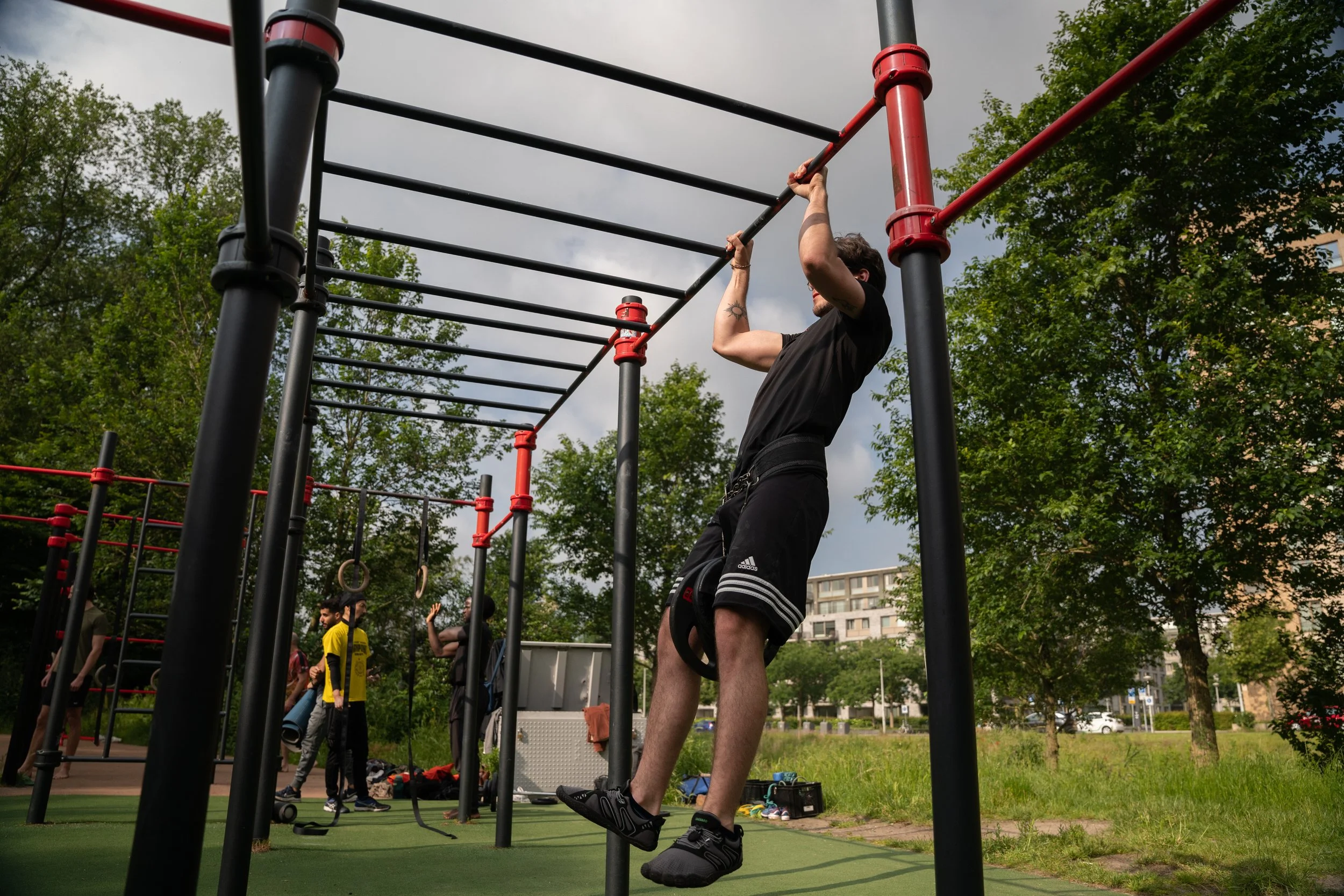 doing pull ups in a park in amsterdam west , rembrandtpark
