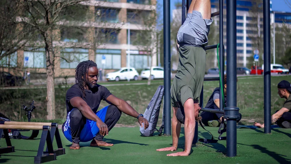 a personal training session where they are doing handstands and calisthenics in amsterdam west 