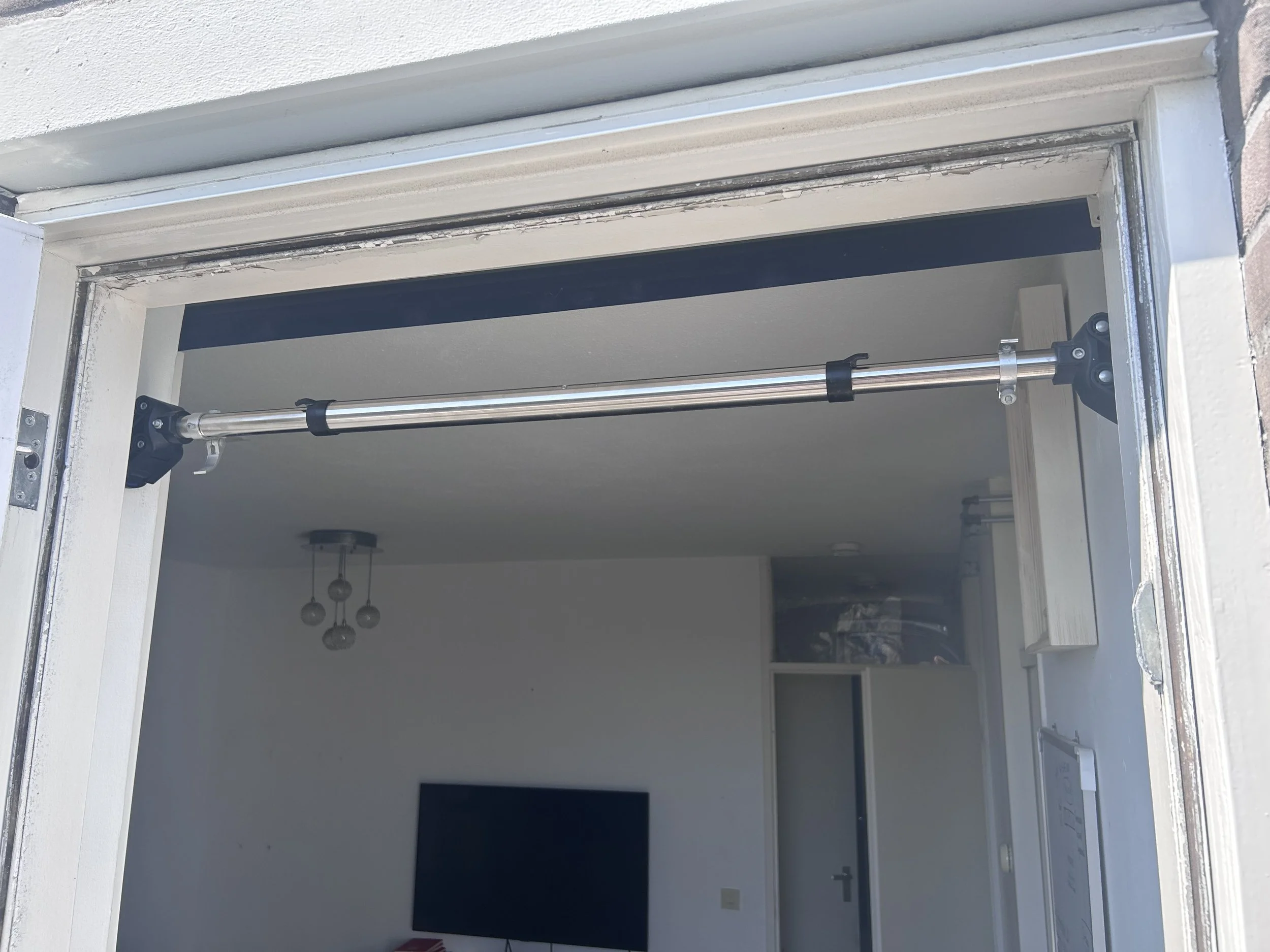 a doorway pull up bar mounted on the doorframe, no screws or drilling required. one of the best options for home pull up bars  because it's so  convenient