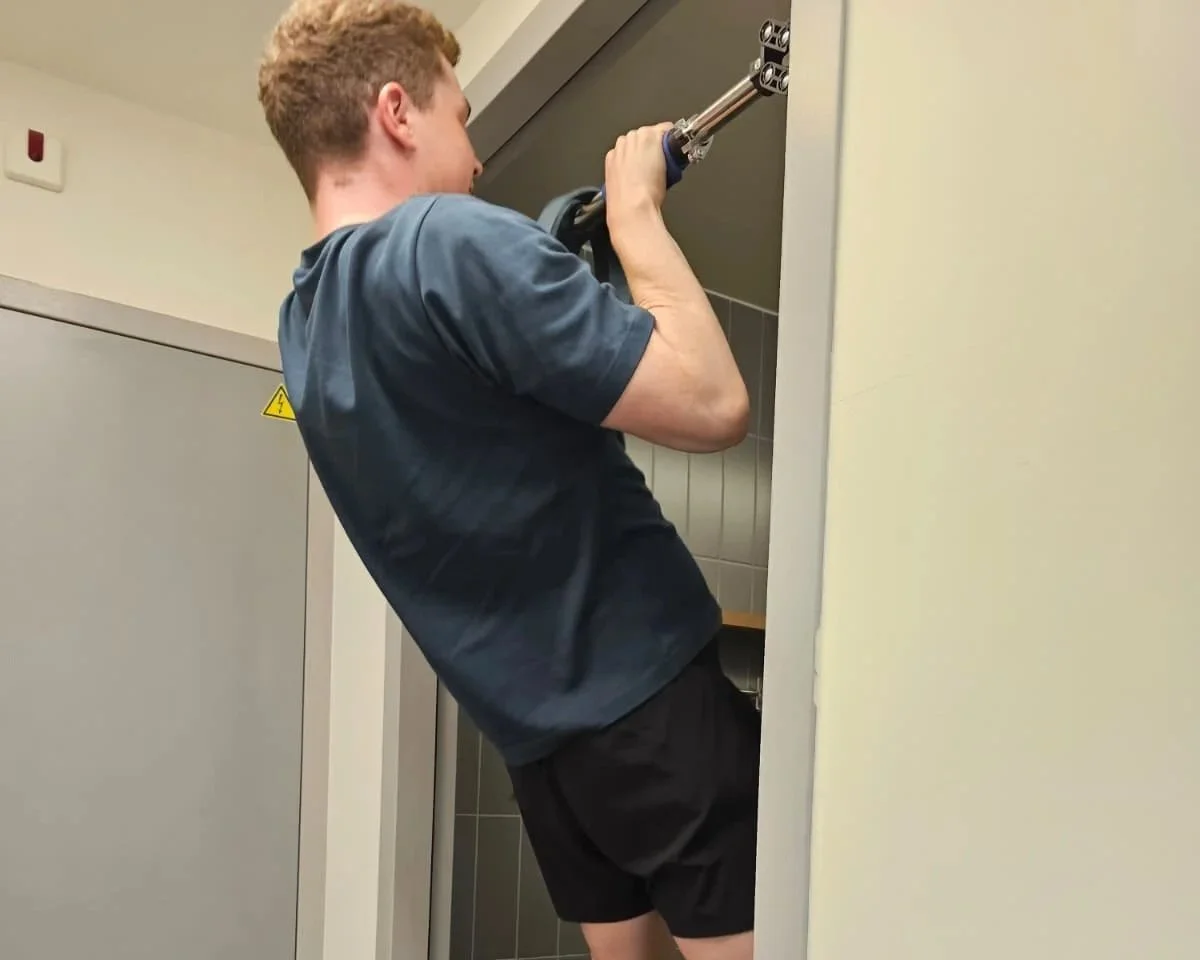 dutch guy doing pull ups on a home pull up bar from famba fitness. the bar is secure and a great way to learn and master pull ups for calisthenics beginners.