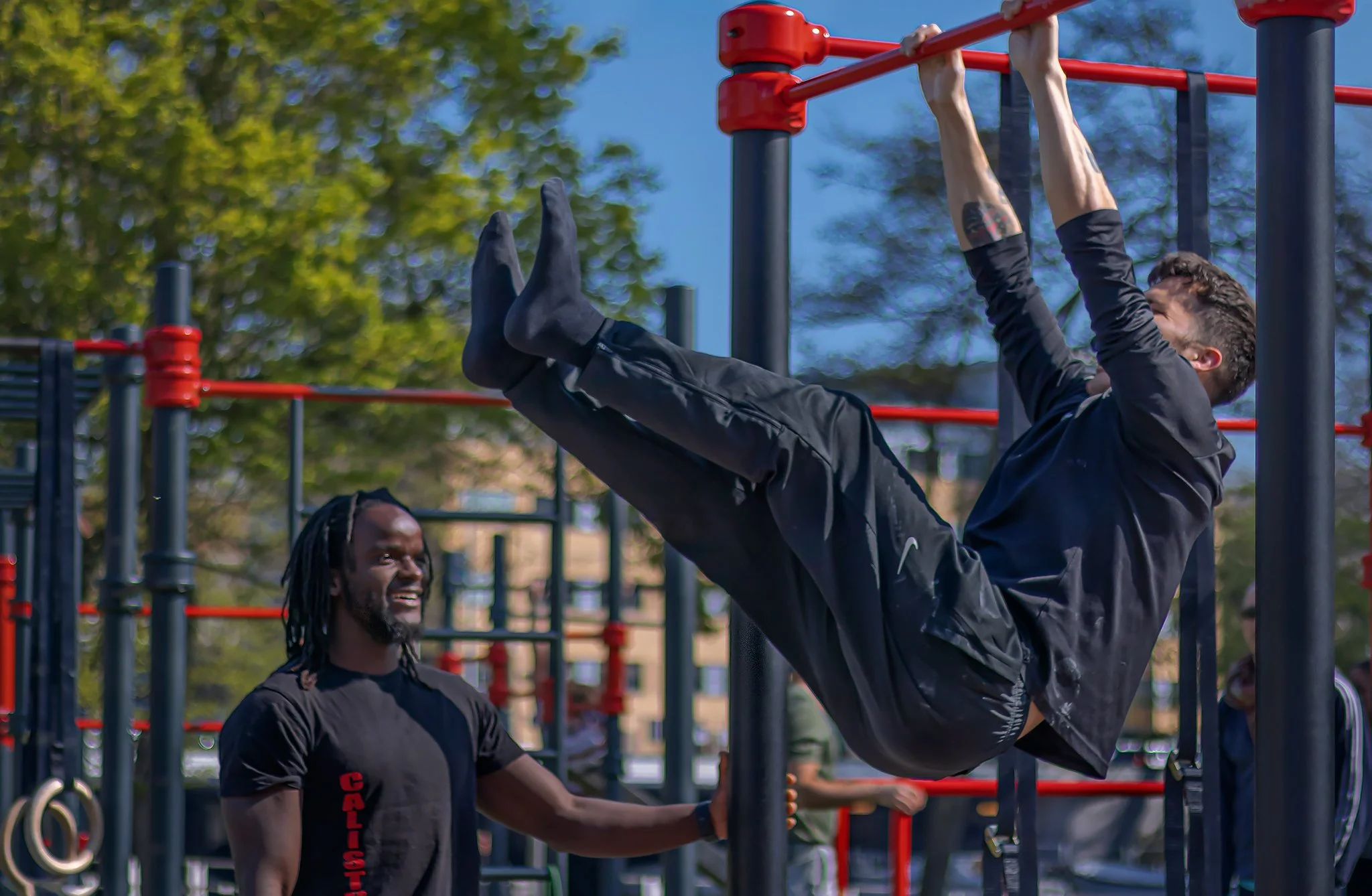 guy does leg raises on a pull up bar in the calisthenics park in rembrandtpark in amsterdam