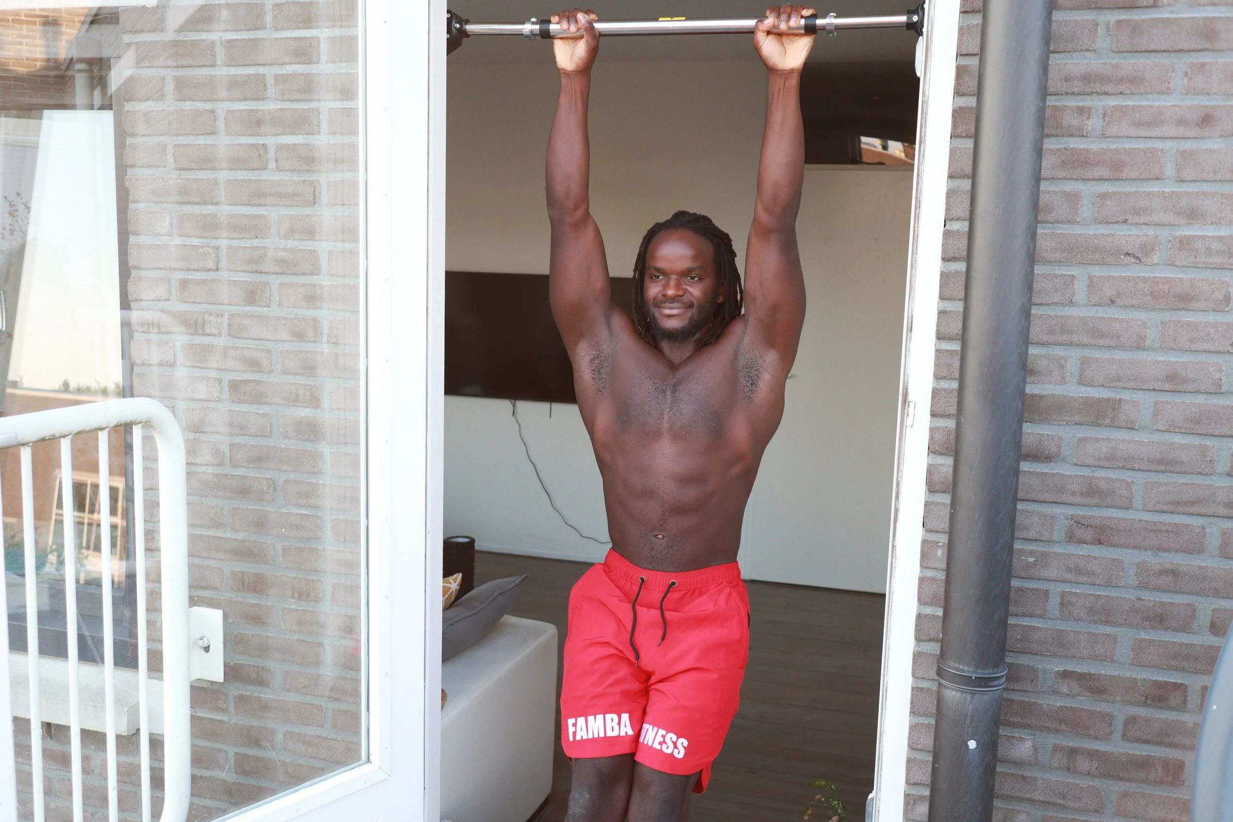 CALISTHENICS beginerr do passive hangs on a famba home pull up bar. the bar requires no screws or drilling to secure on the wall.