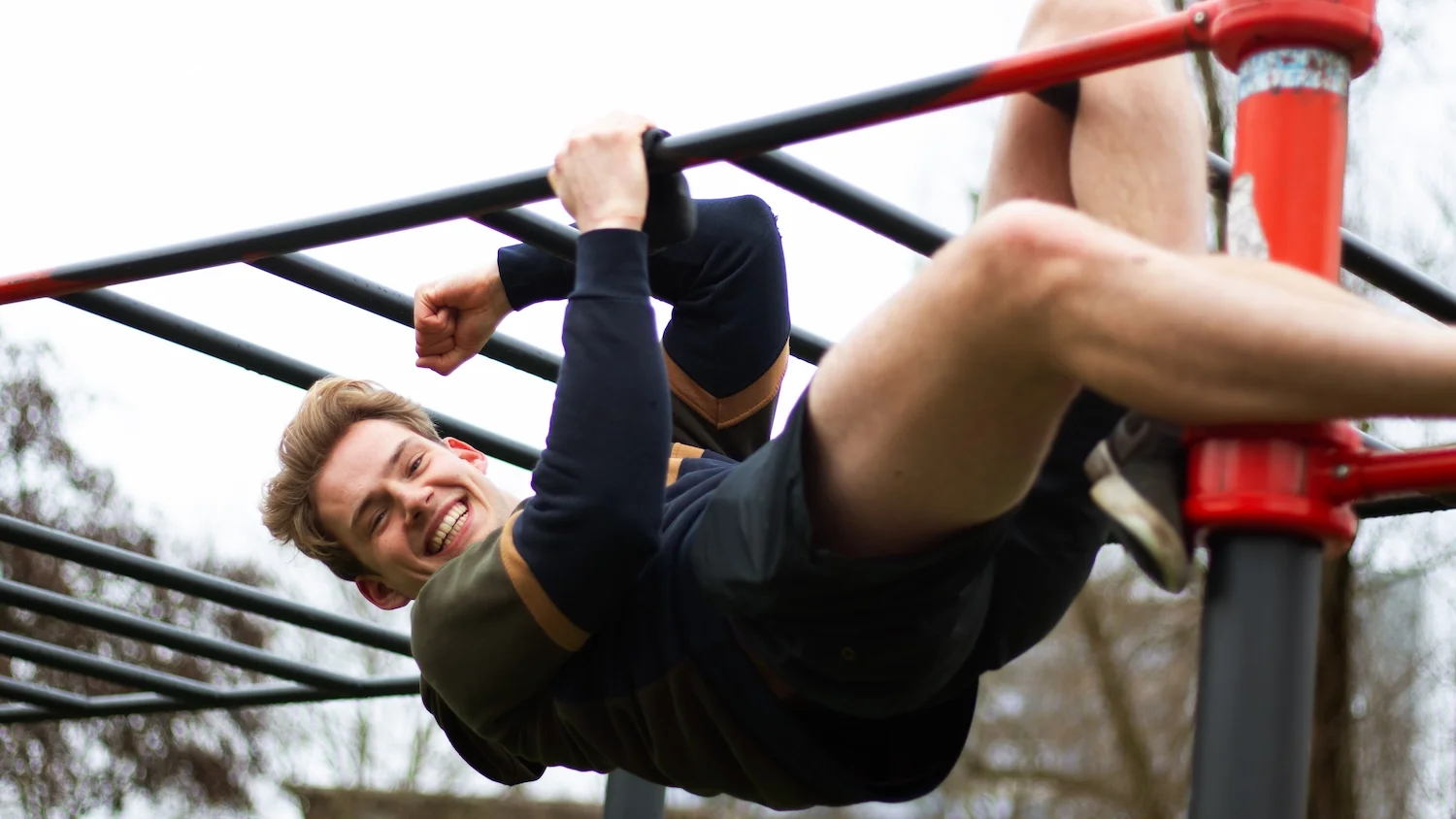 guy does a calisthenics exercise on the bar during a personal training lesson in amsterdam west