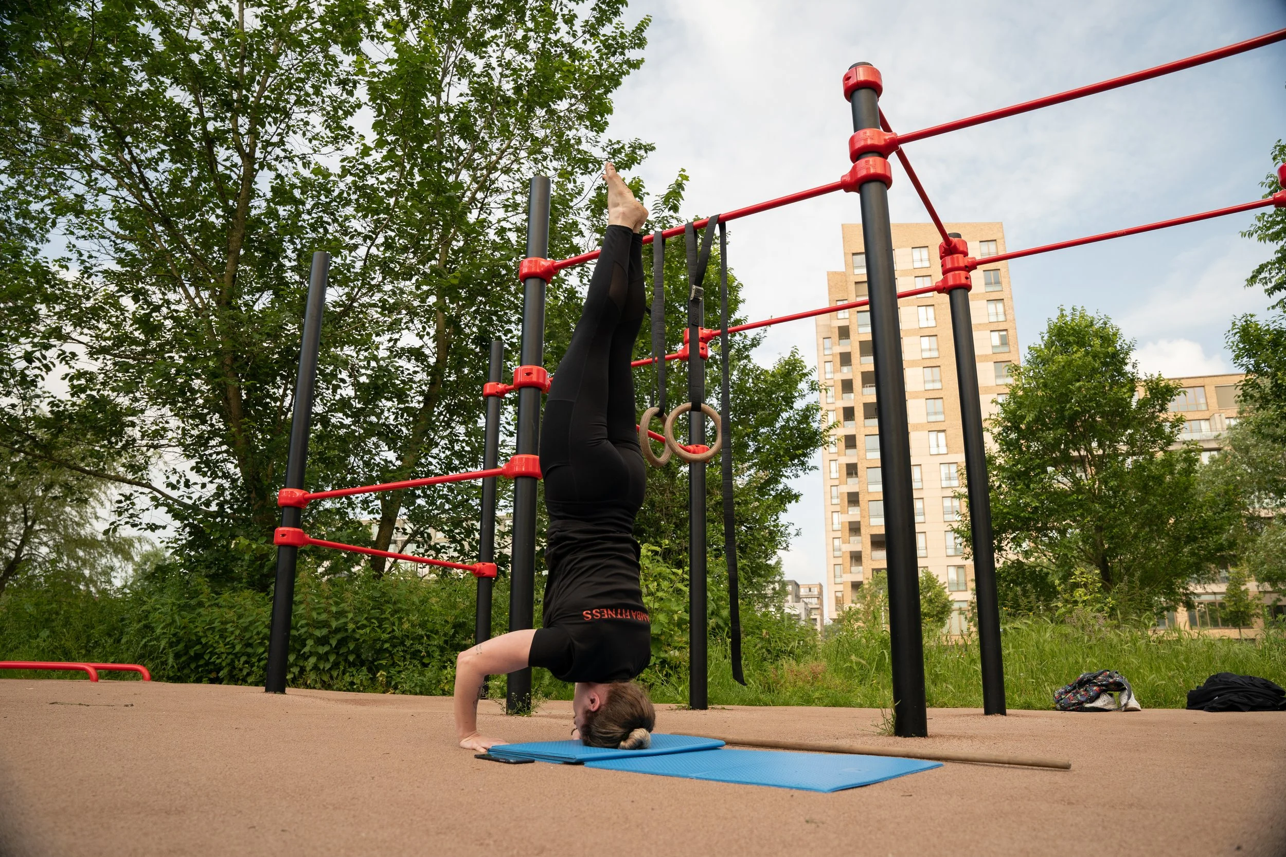 A woman over 30 years old, training calisthenics in a group lesson at Famba, a calisthenics gym in Rembrandtpark amsterdam west.