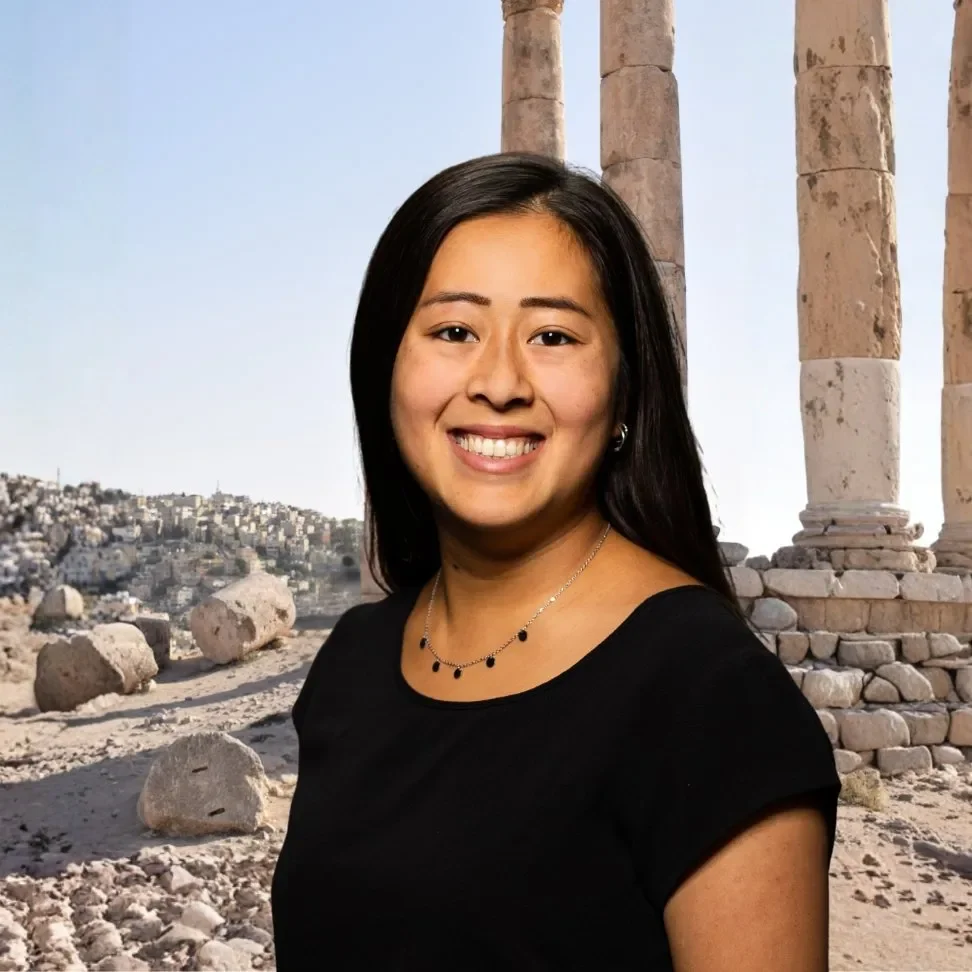 A woman with long, black hair and black eyes, smiling, wearing a black shirt.