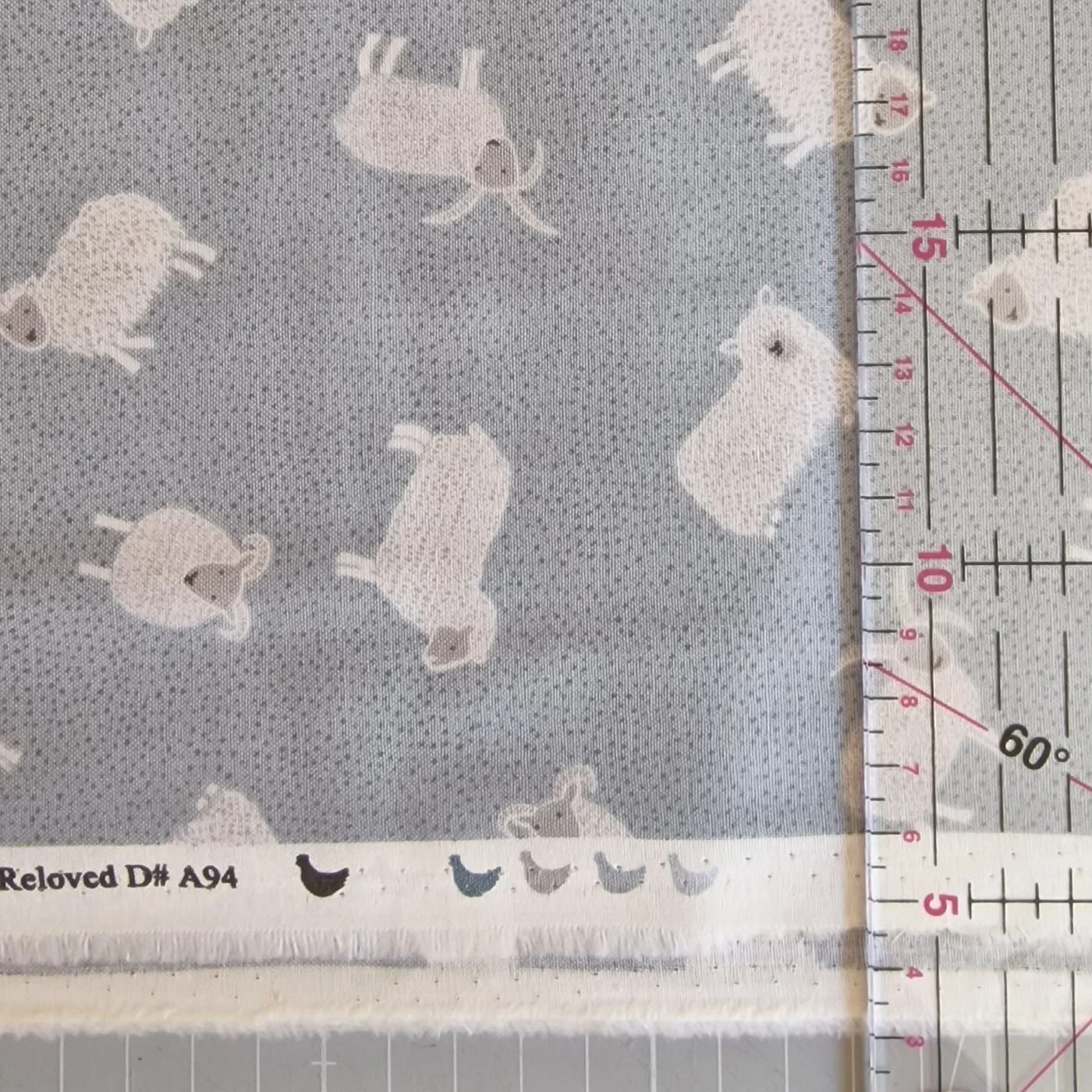 Ruler over cotton fabric by Lewis and Irene, Countrylife, showing scale of sheep pattern