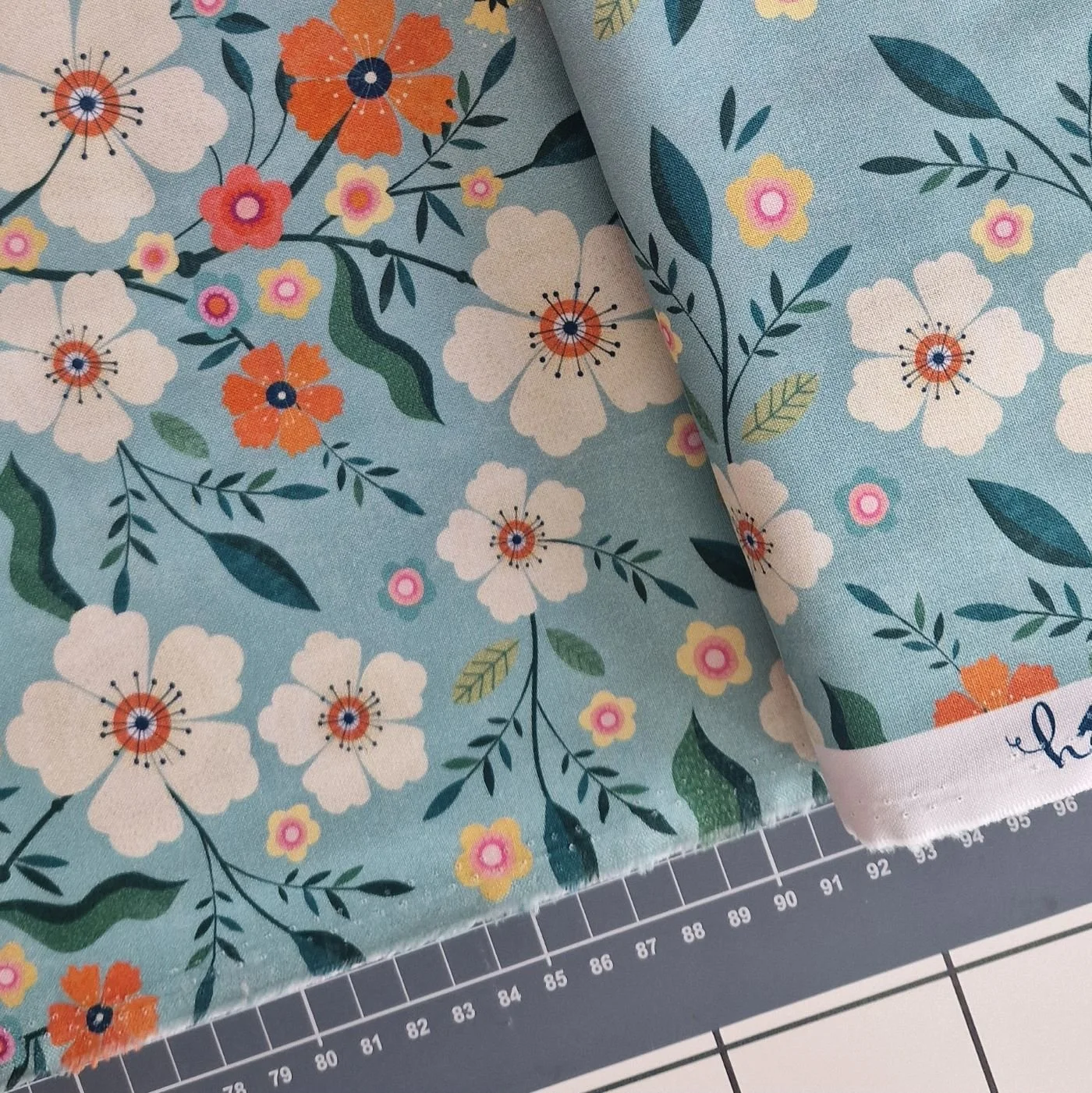 Light blue cotton fabric with orange and white flowers