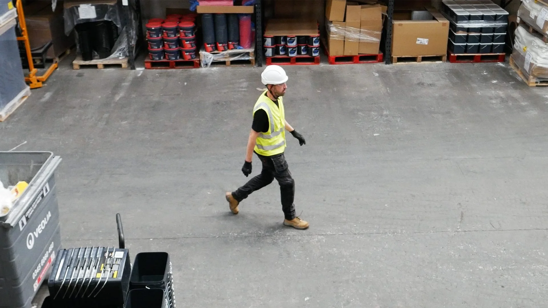 Engineer wearing protective equipment walking through an industrial workshop