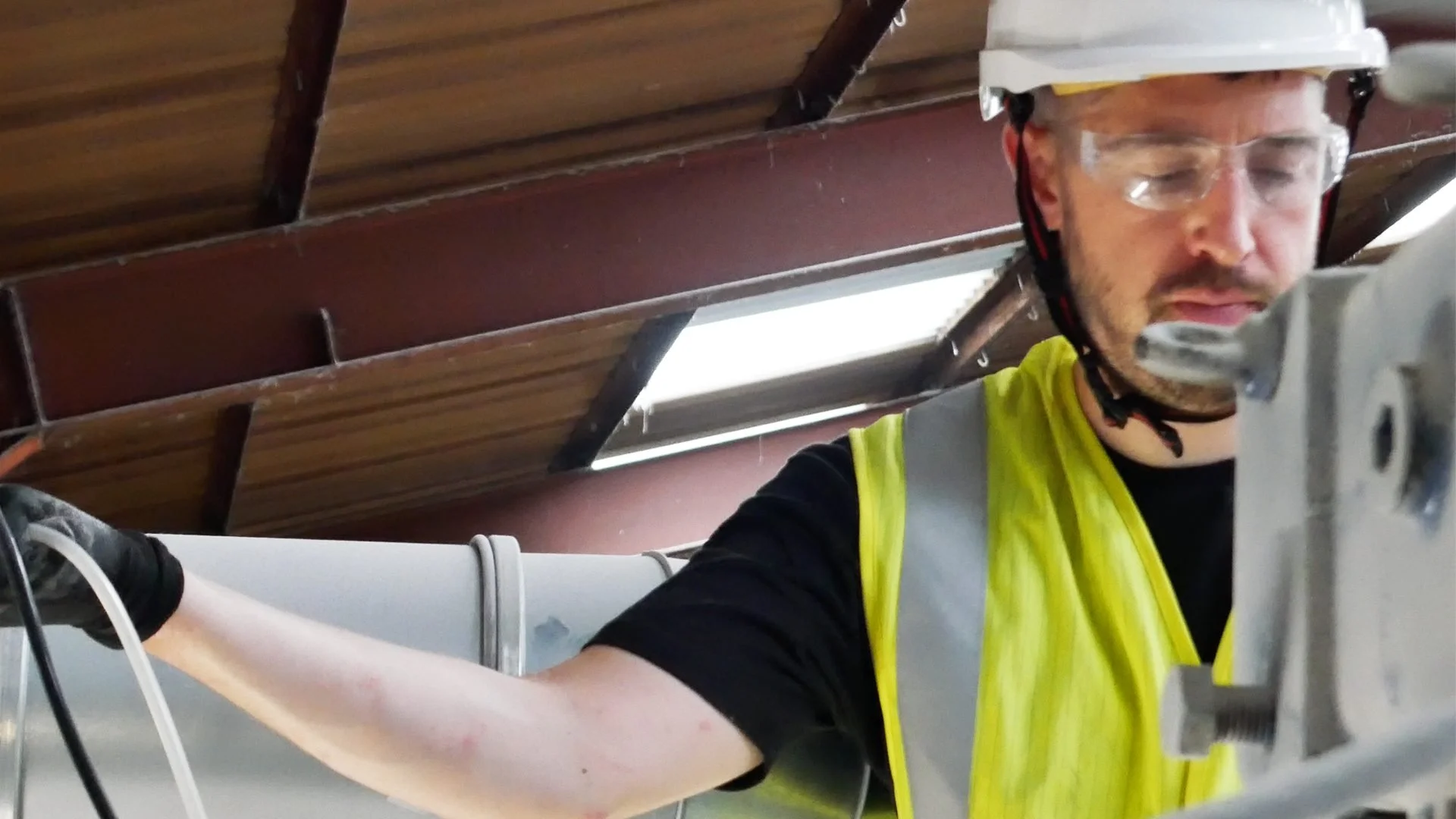 Engineer wearing protective equipment inspecting an industrial extraction unit