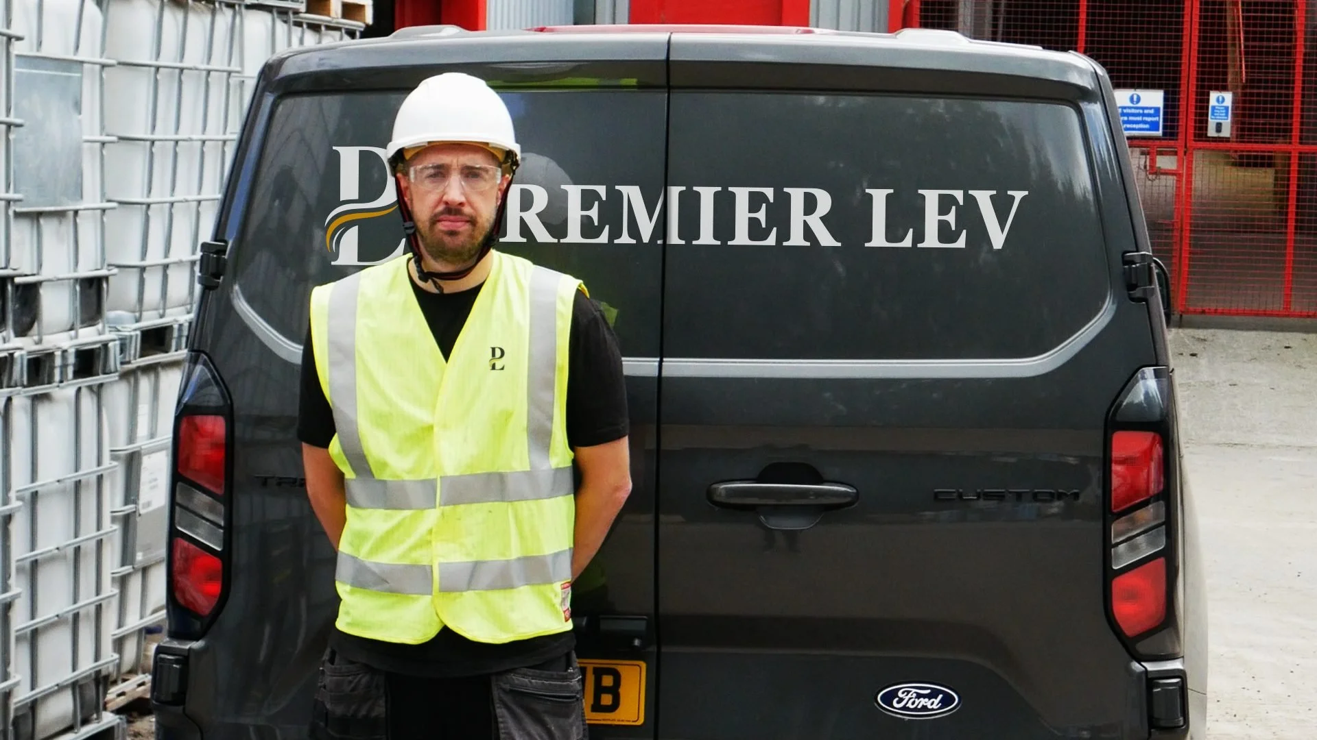 LEV engineer wearing a hard hat and high-visibility vest beside a Premier LEV van