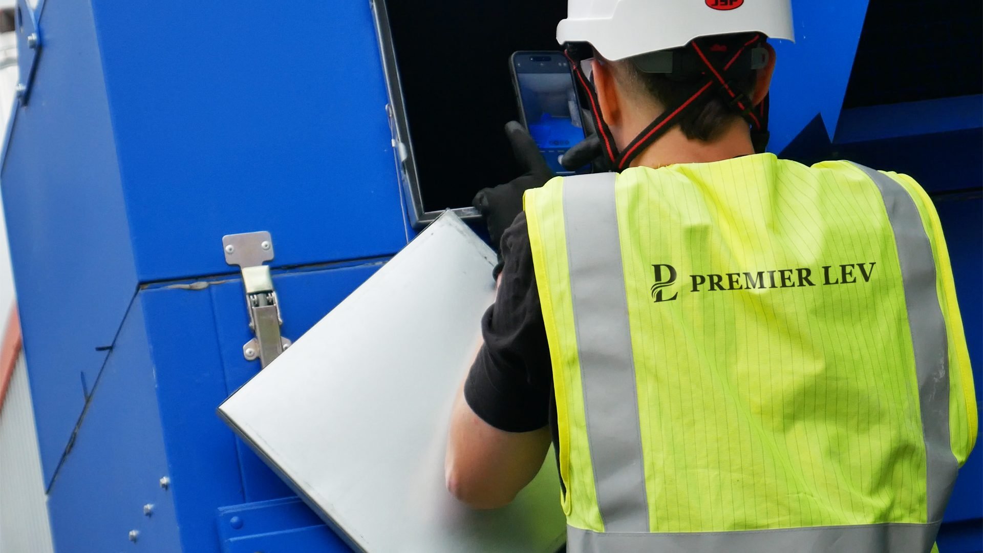 Engineer handling a panel beside an industrial extraction unit