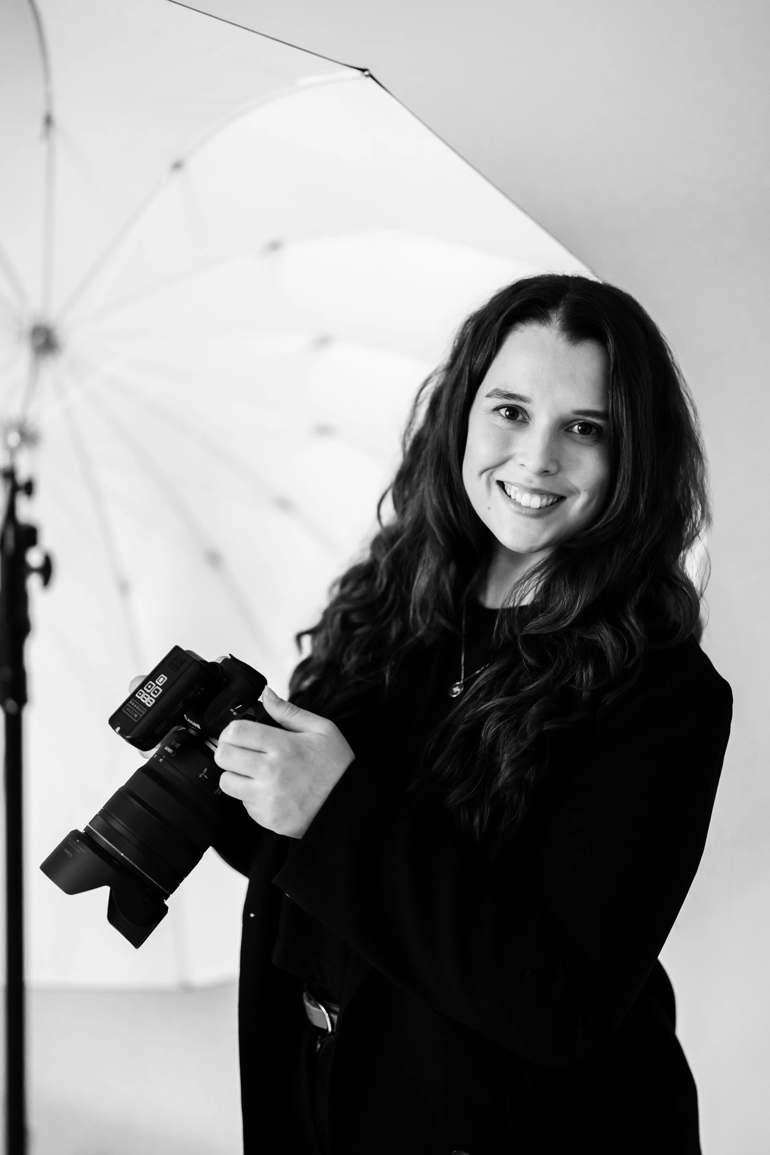 A professional studio photographer based in Sydney, posing in her studio with photography gear.