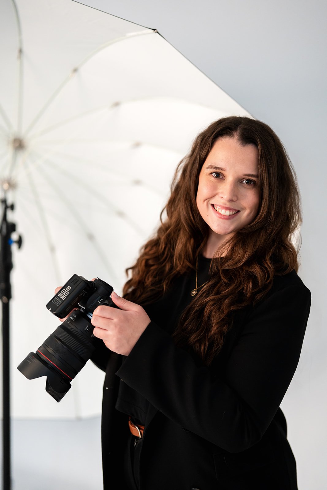 A professional studio photographer based in Sydney, posing in her studio with photography gear.