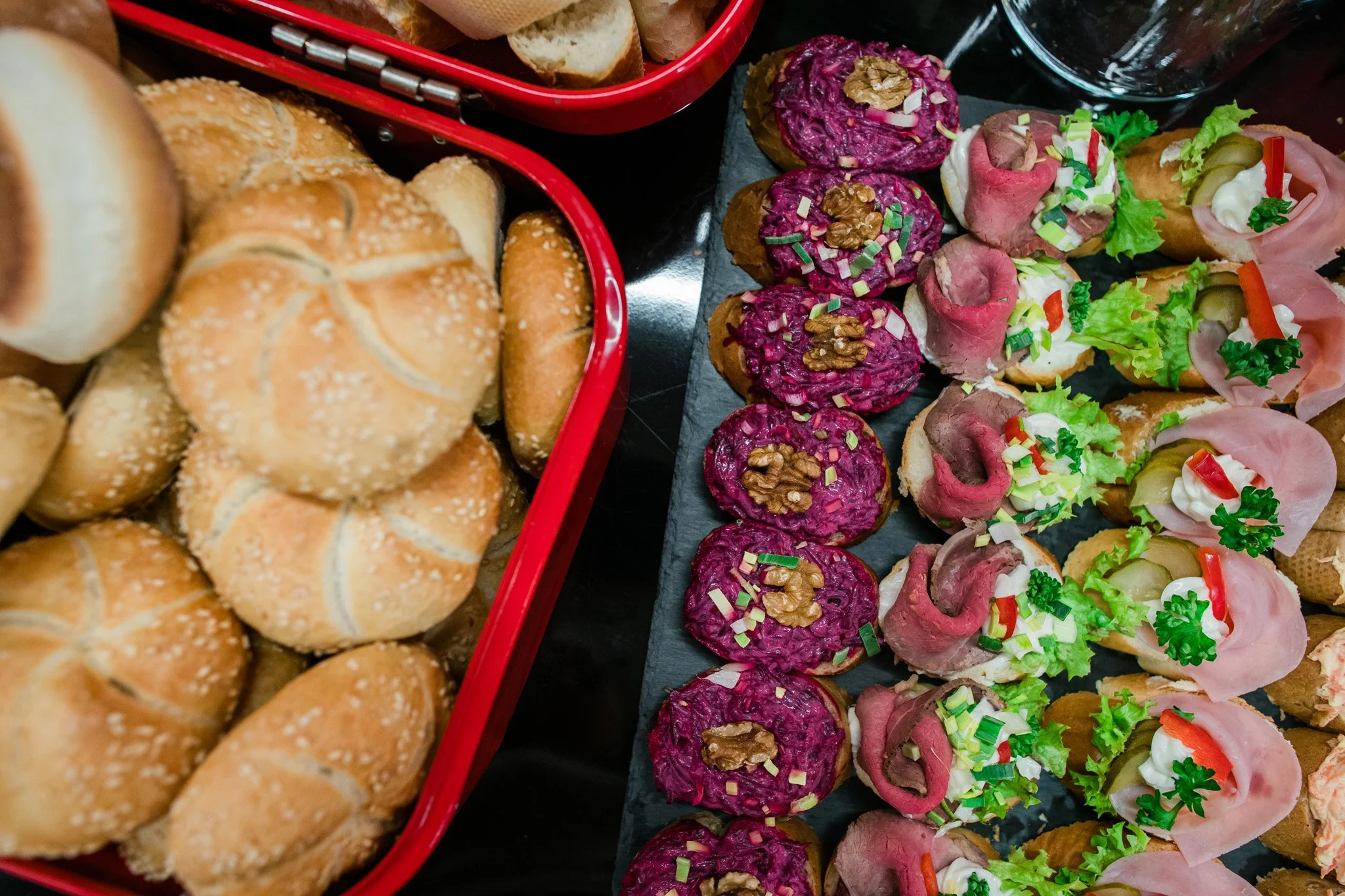 Assorted appetizers and bread rolls displayed on a platter and in a basket. Catering, culinary and food photography in Zürich, Zug, Bern, Lucerne, Basel, St. Gallen and across Switzerland.