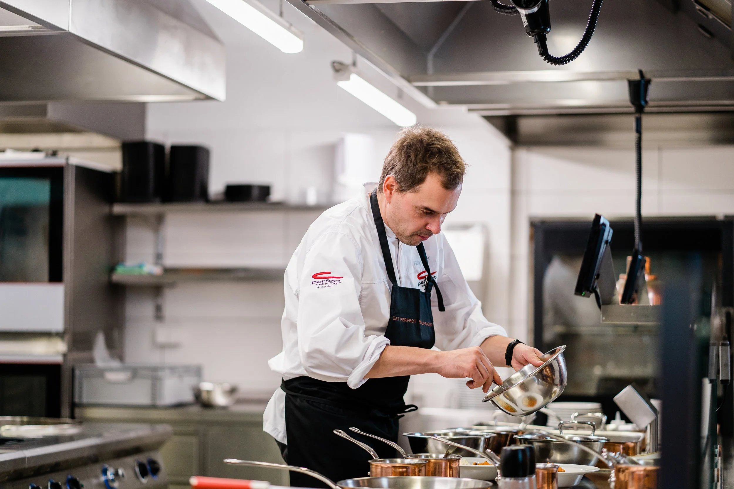 Chef preparing food in a professional kitchen with cooking utensils and appliances. Personal branding and fine dining restaurant photography in Zürich, Zug, Bern, Lucerne, Basel, St. Gallen and across Switzerland.