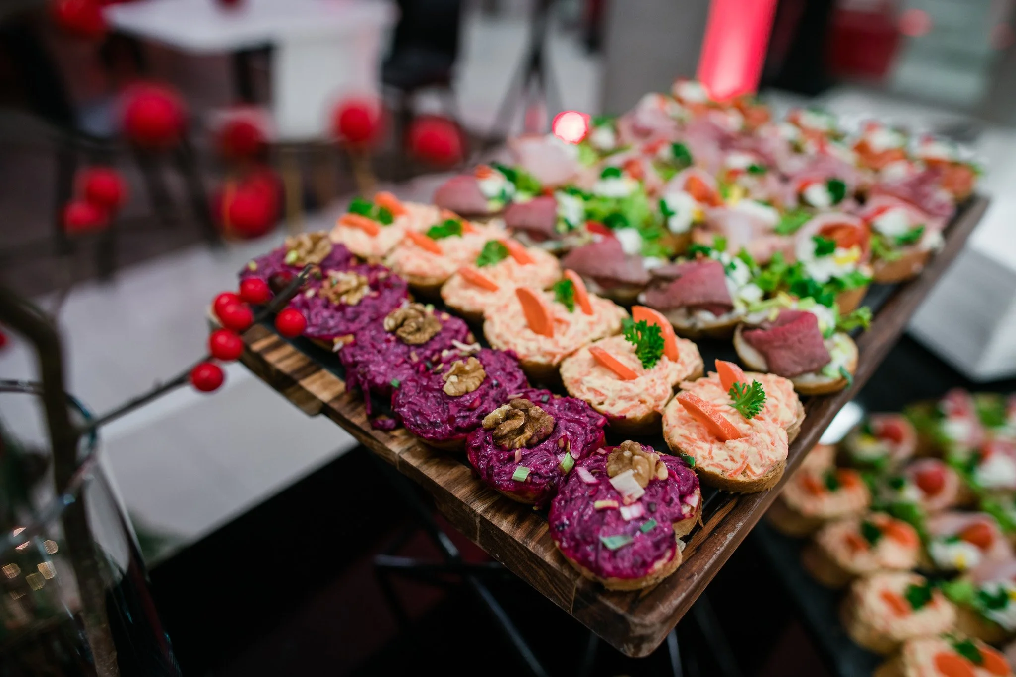 Tray of assorted open-faced sandwiches with colorful toppings, including beet spread with walnuts, smoked salmon, avocado, and herbs. Catering and food photography in Zürich, Zug, Bern, Lucerne, Basel, St. Gallen and across Switzerland.