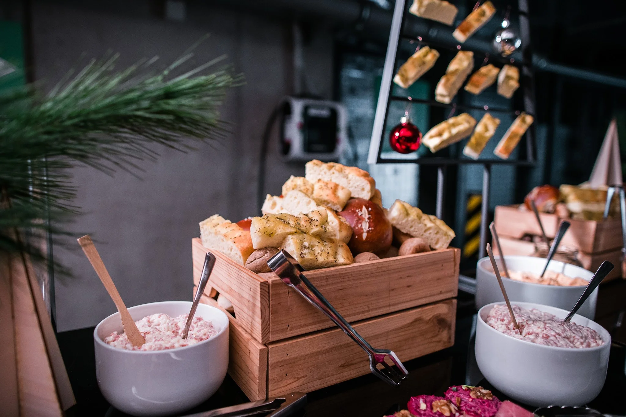 Christmas cheese and charcuterie display with bowls of spreads and bread, decorated with holiday ornaments. Catering and food photography in Zürich, Zug, Bern, Lucerne, Basel, St. Gallen and across Switzerland.